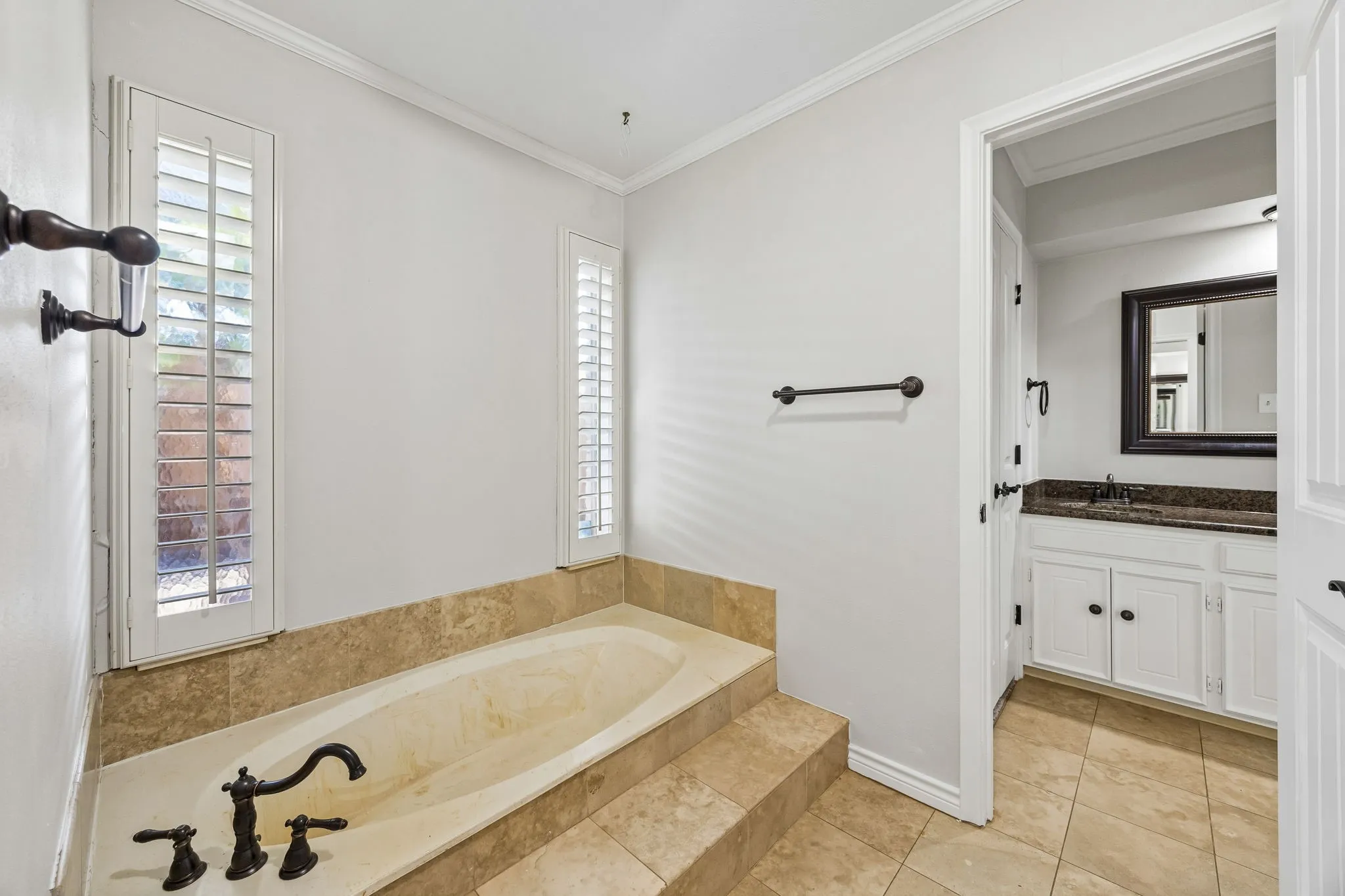 Primary bath featuring separate vanities and closets, and separate tub and walk-in shower.