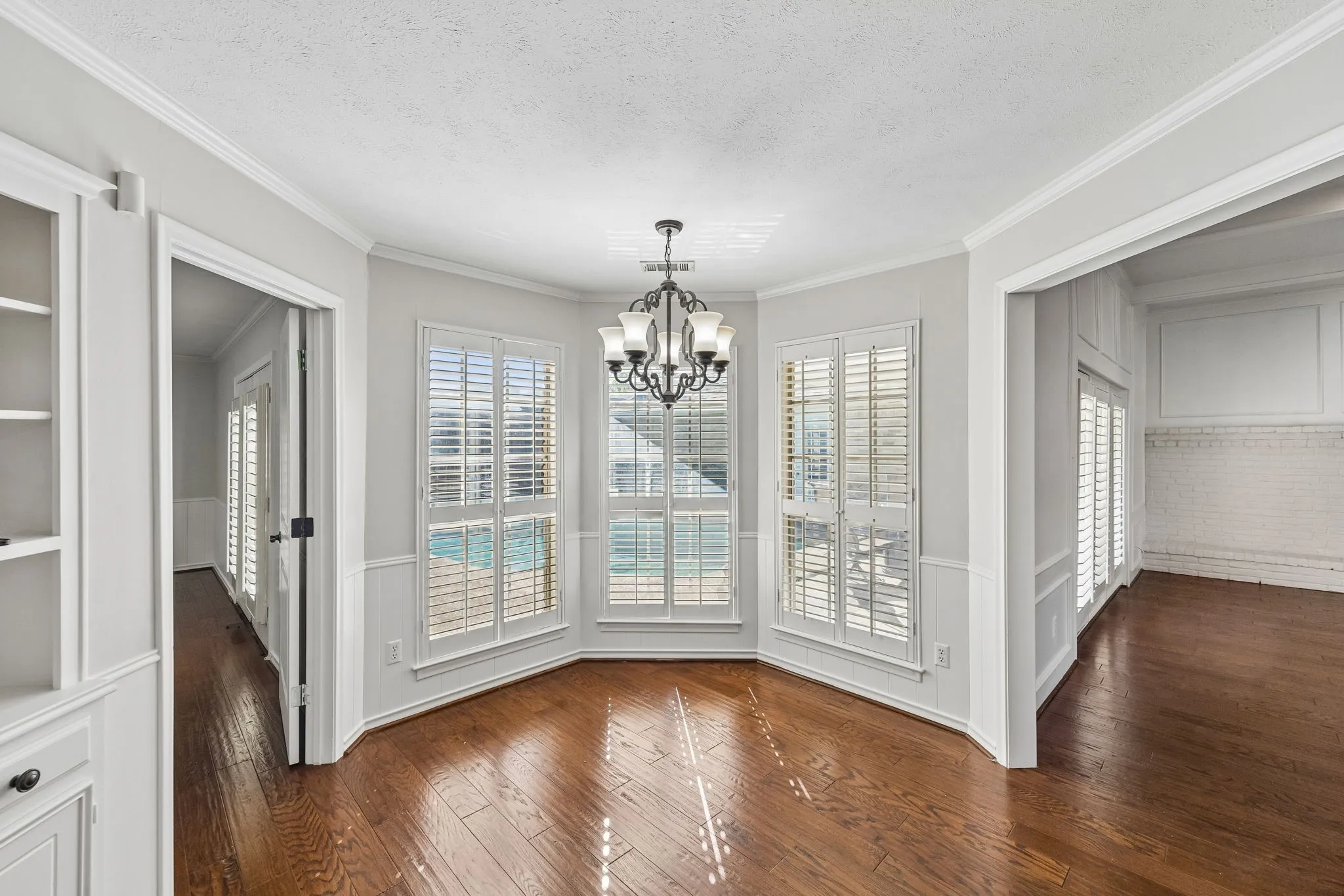 Breakfast room features hardwood flooring, built-in hutch, and overlooks the sparkling pool.