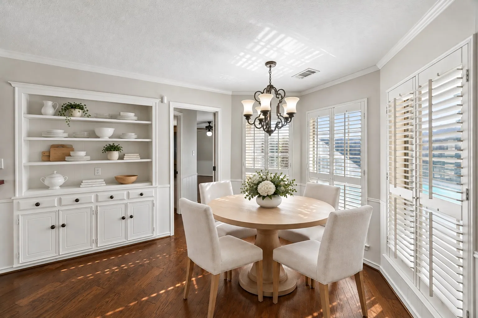 Eat-in kitchen with built-in hutch and overlooking pool. This photo is virtually staged.