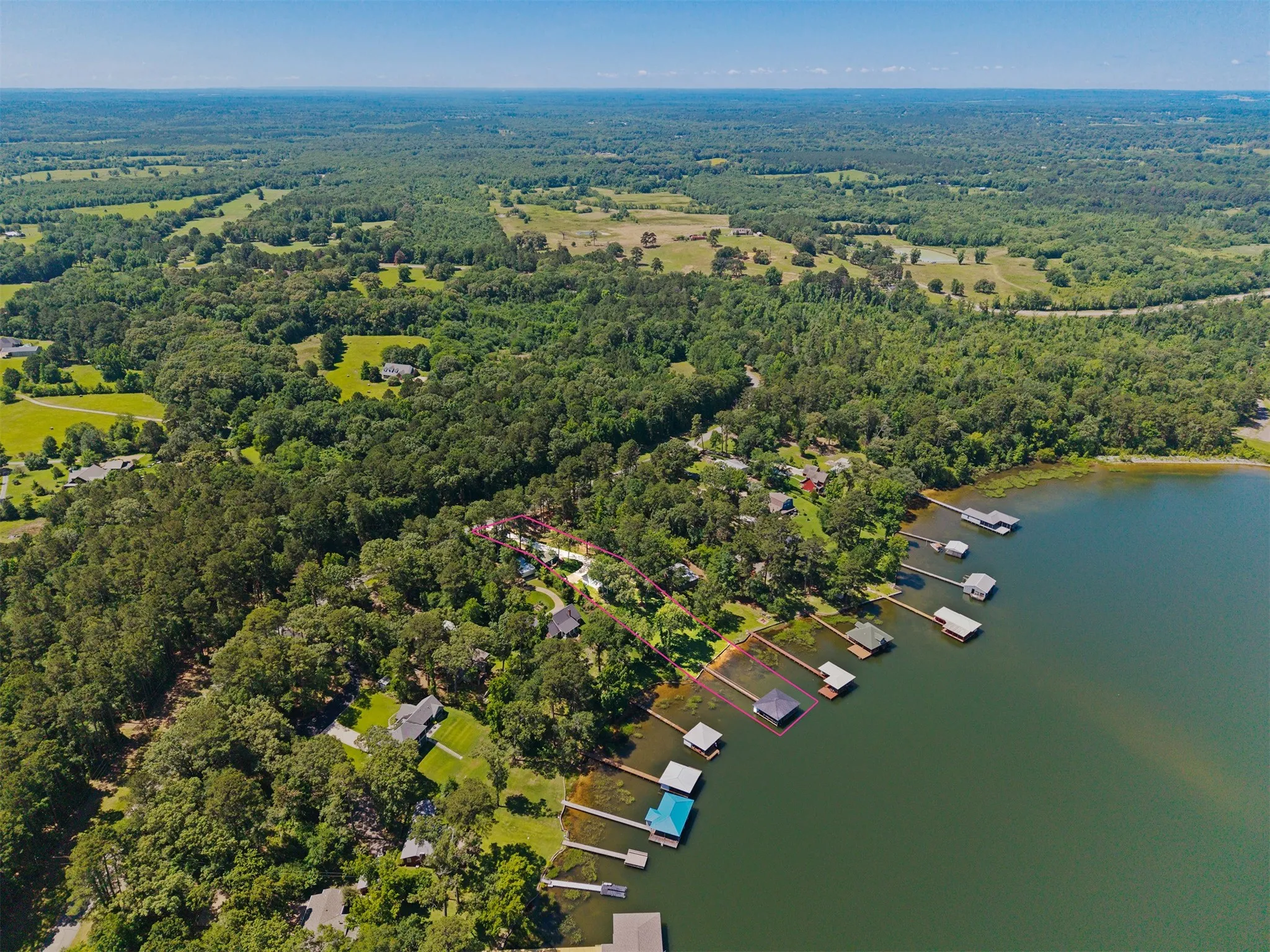 Expansive waterfront property featuring a private dock and a mature tree-lined landscape