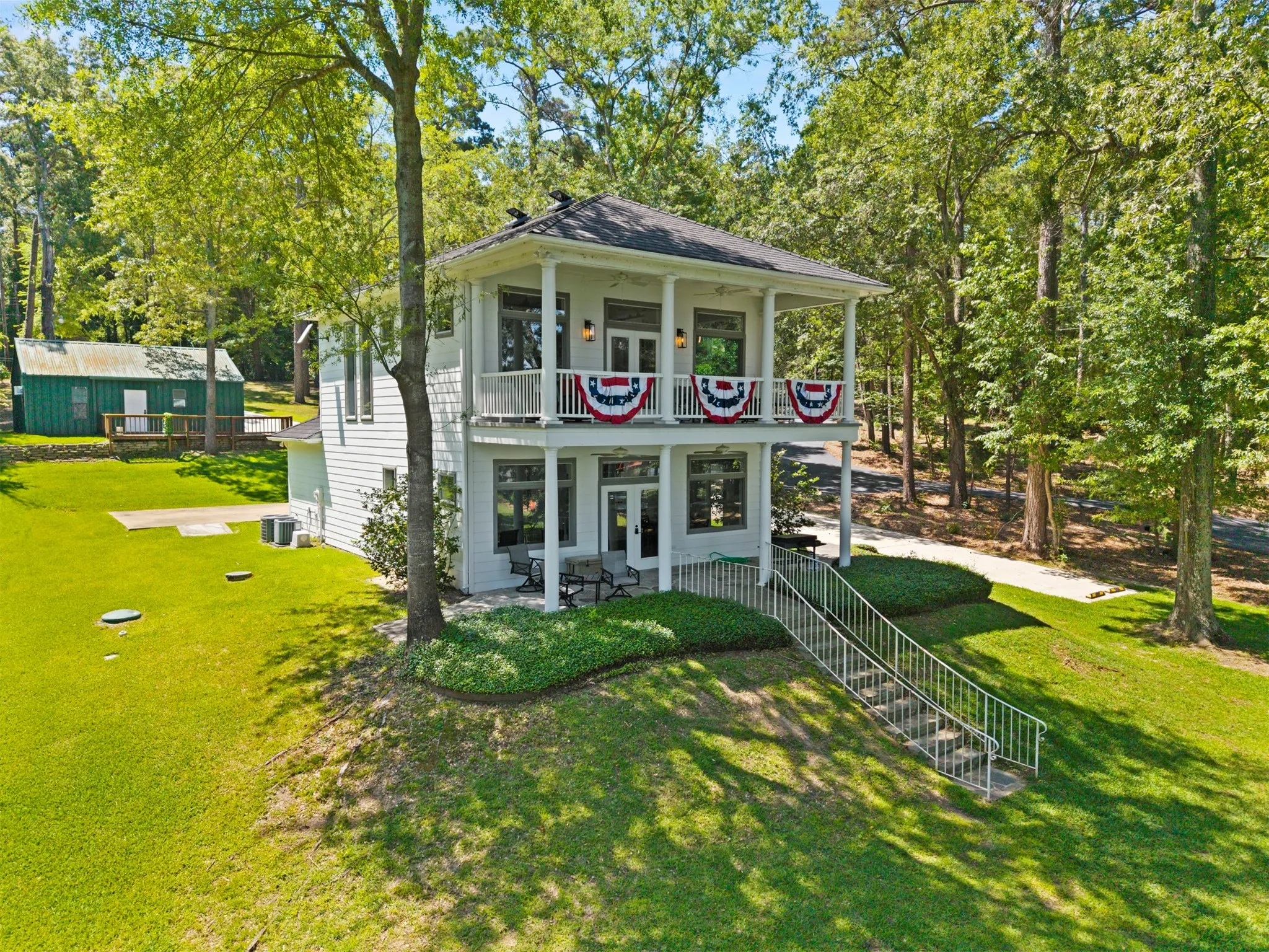 Two-story exterior with dual covered balconies, white siding, and a dark shingle roof