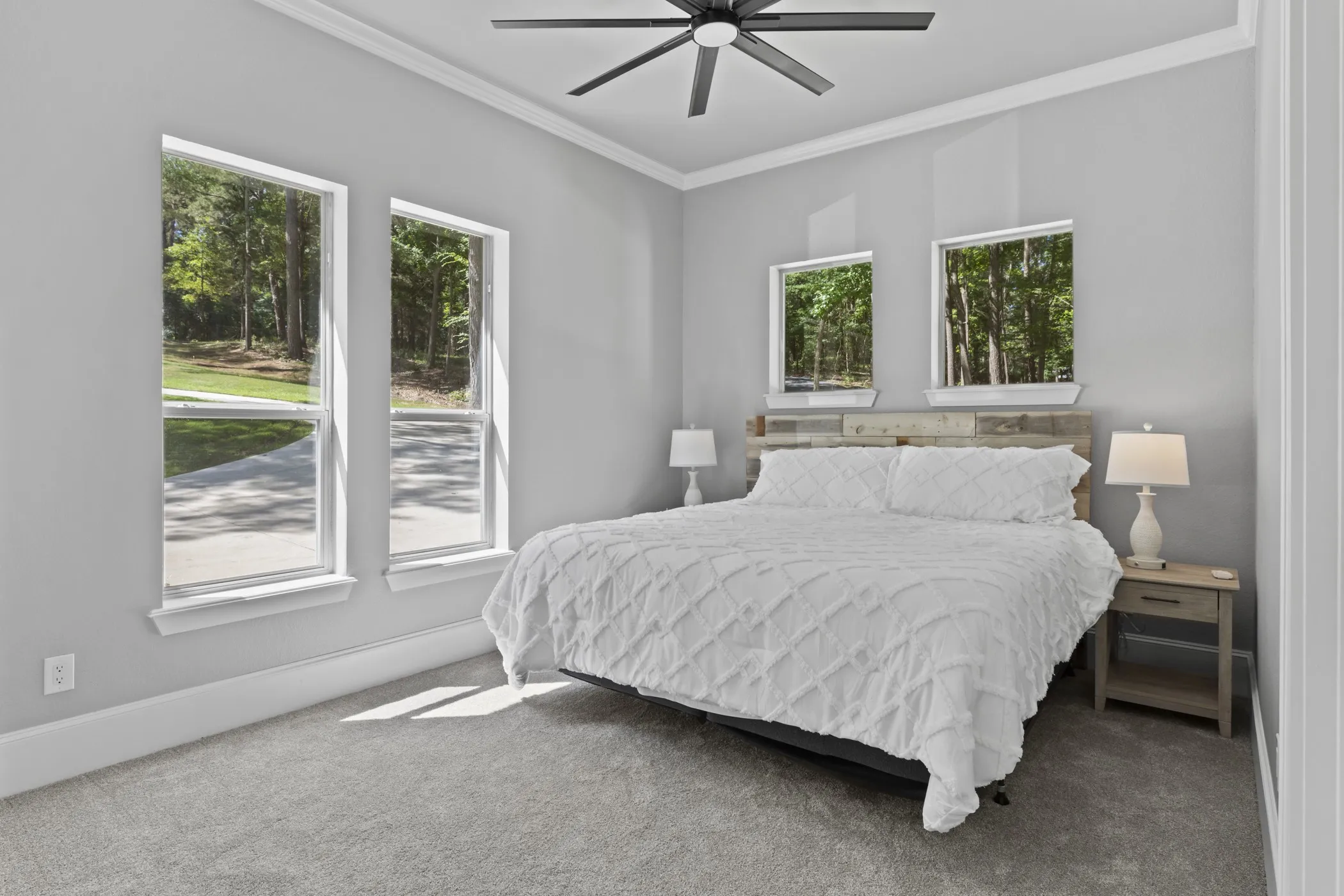 Wall-to-wall carpeting, multiple windows, crown molding, and a ceiling fan