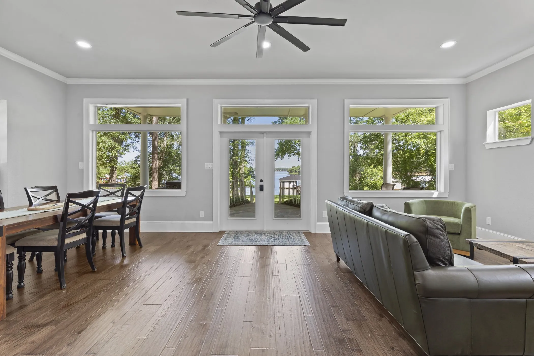 Expansive living area with wood-finish flooring, recessed lighting, and a ceiling fan