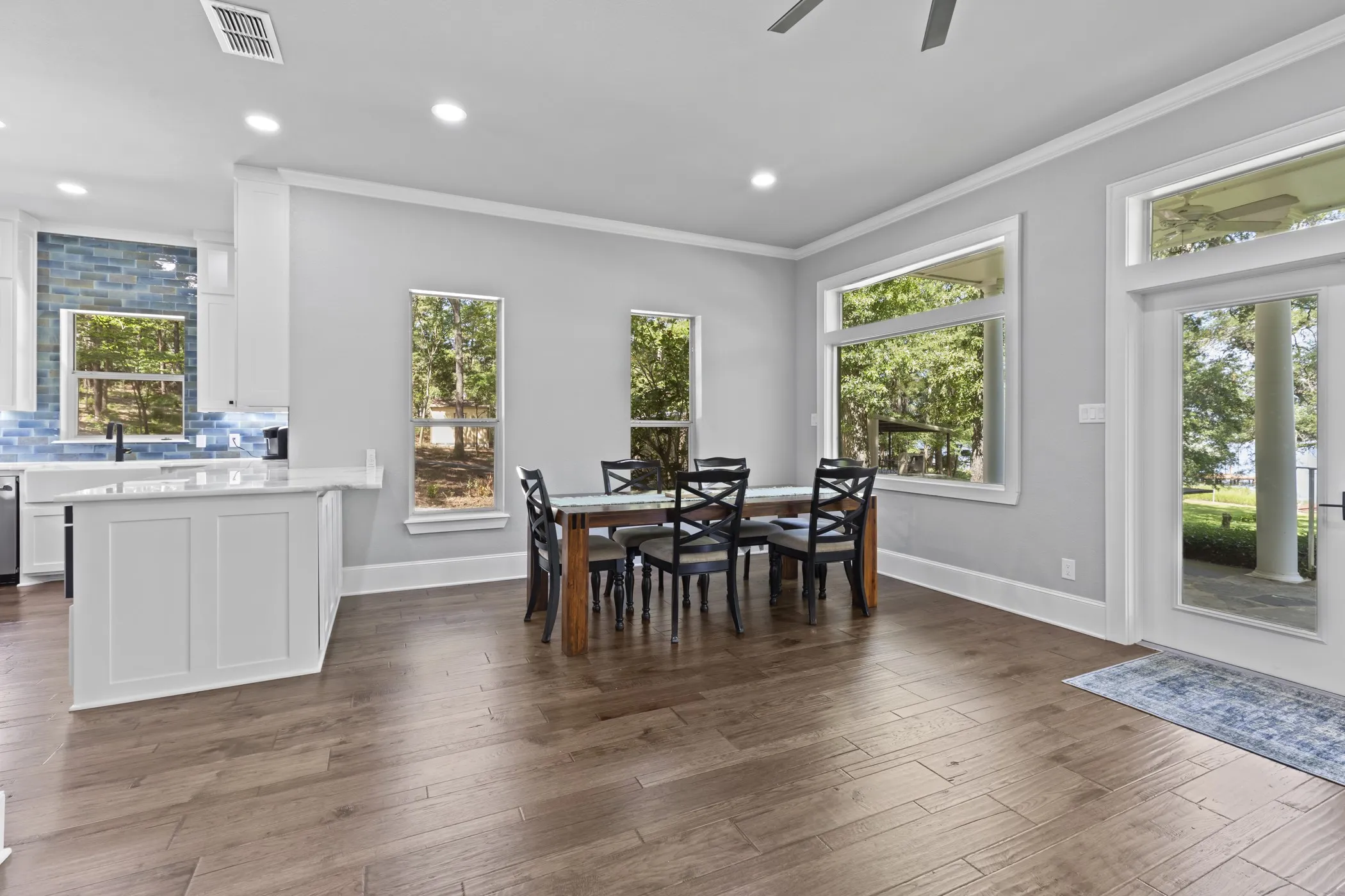 Spacious dining area with wood-finish flooring, recessed lighting, and crown molding