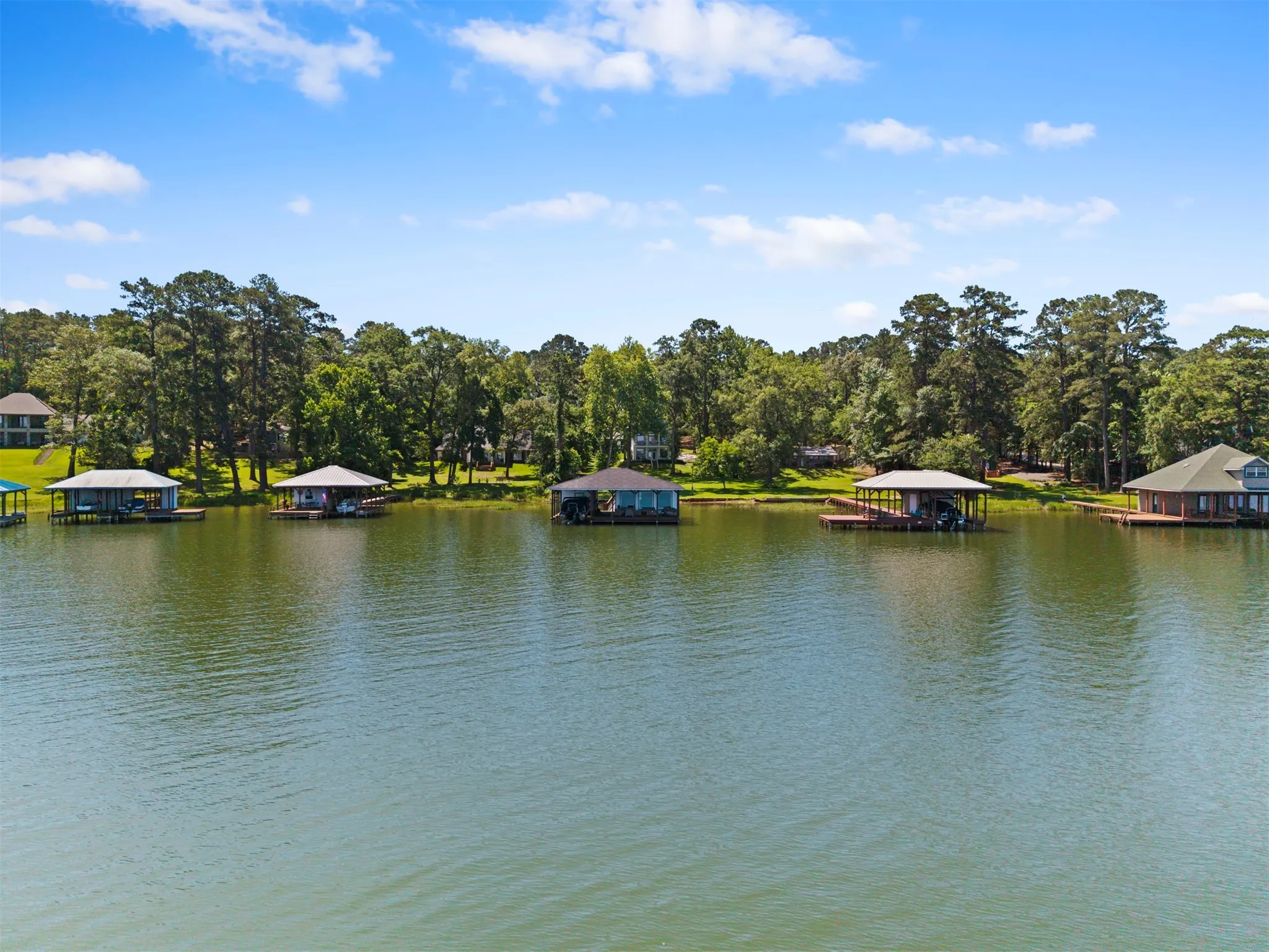 Waterfront property featuring boat docks with covered slips and direct lake access