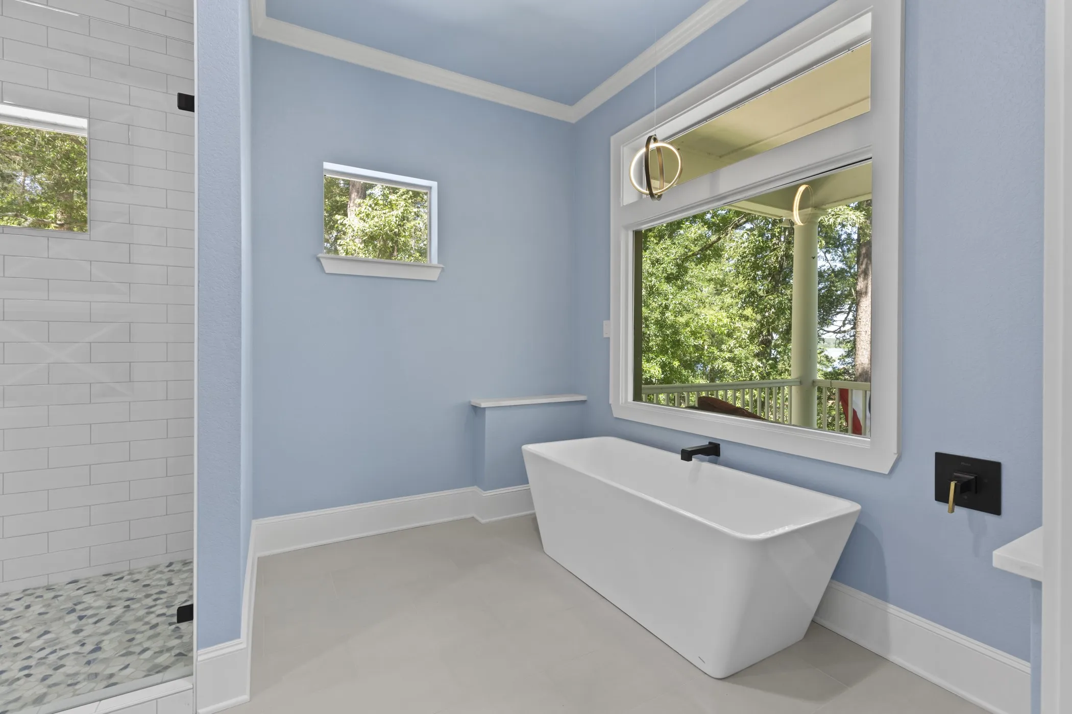 Freestanding soaking tub with wall-mounted matte black faucet