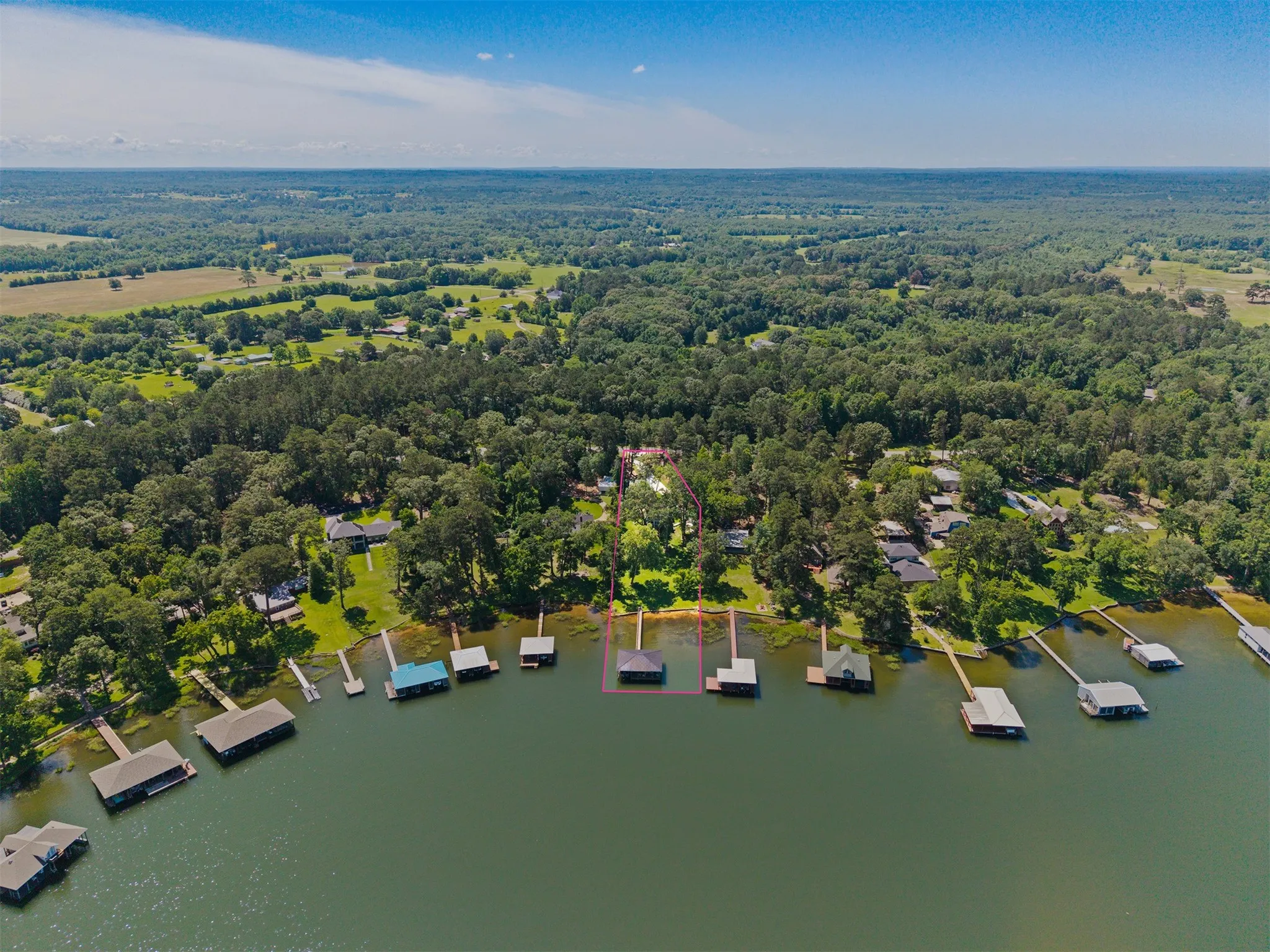 Waterfront property featuring a private boat house with a covered slip and an additional uncovered dock