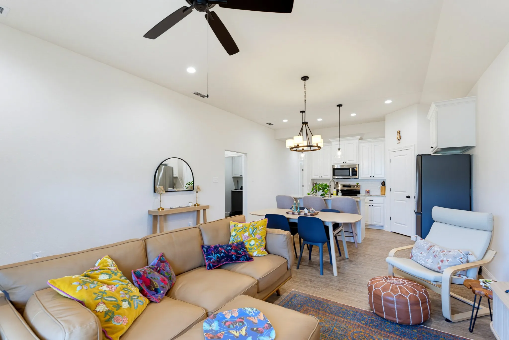 Open-concept living space featuring high ceilings, recessed lighting, a modern ceiling fan, and wood-finish flooring