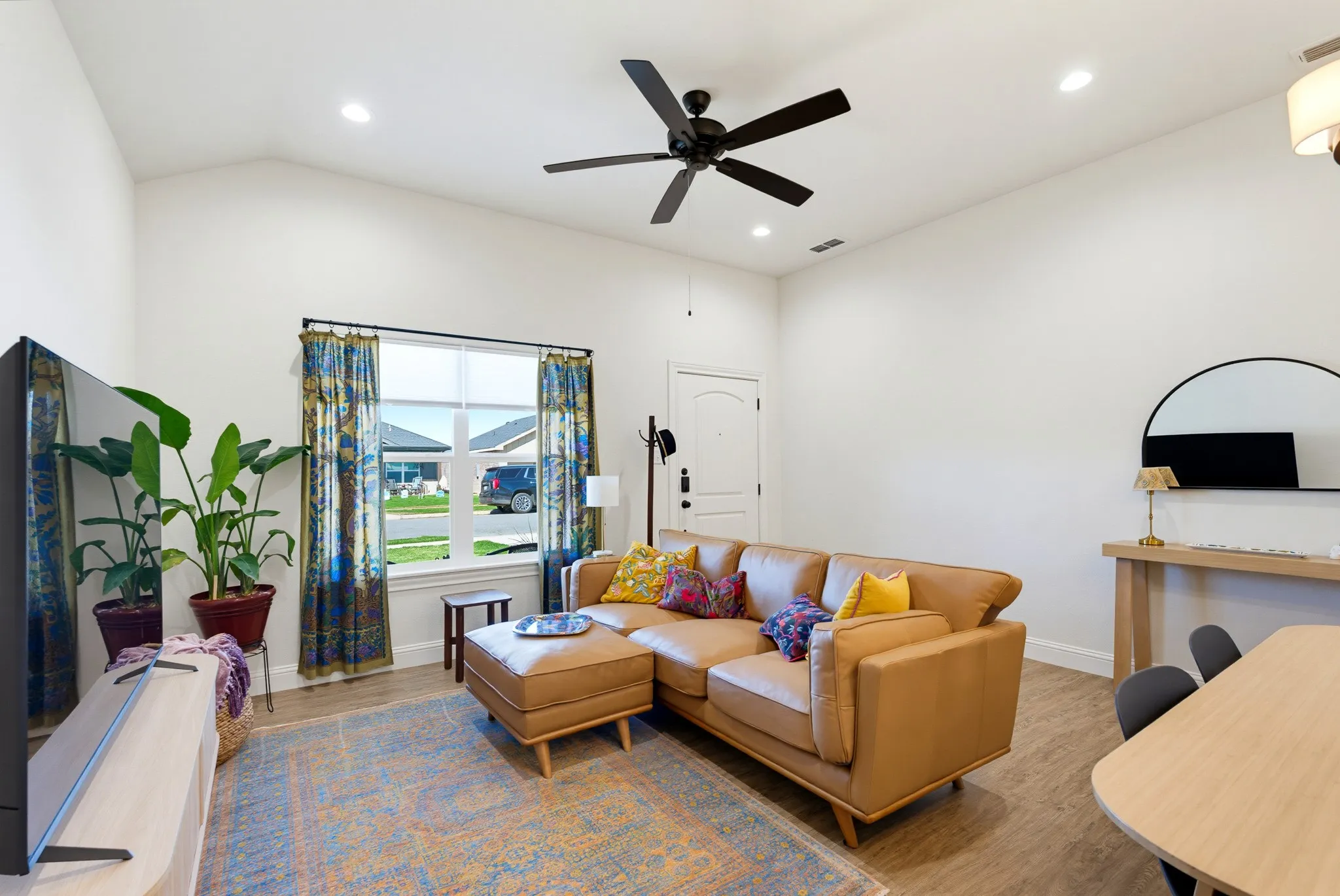 Vaulted ceilings, wood-finish flooring, recessed lighting, and a contemporary ceiling fan