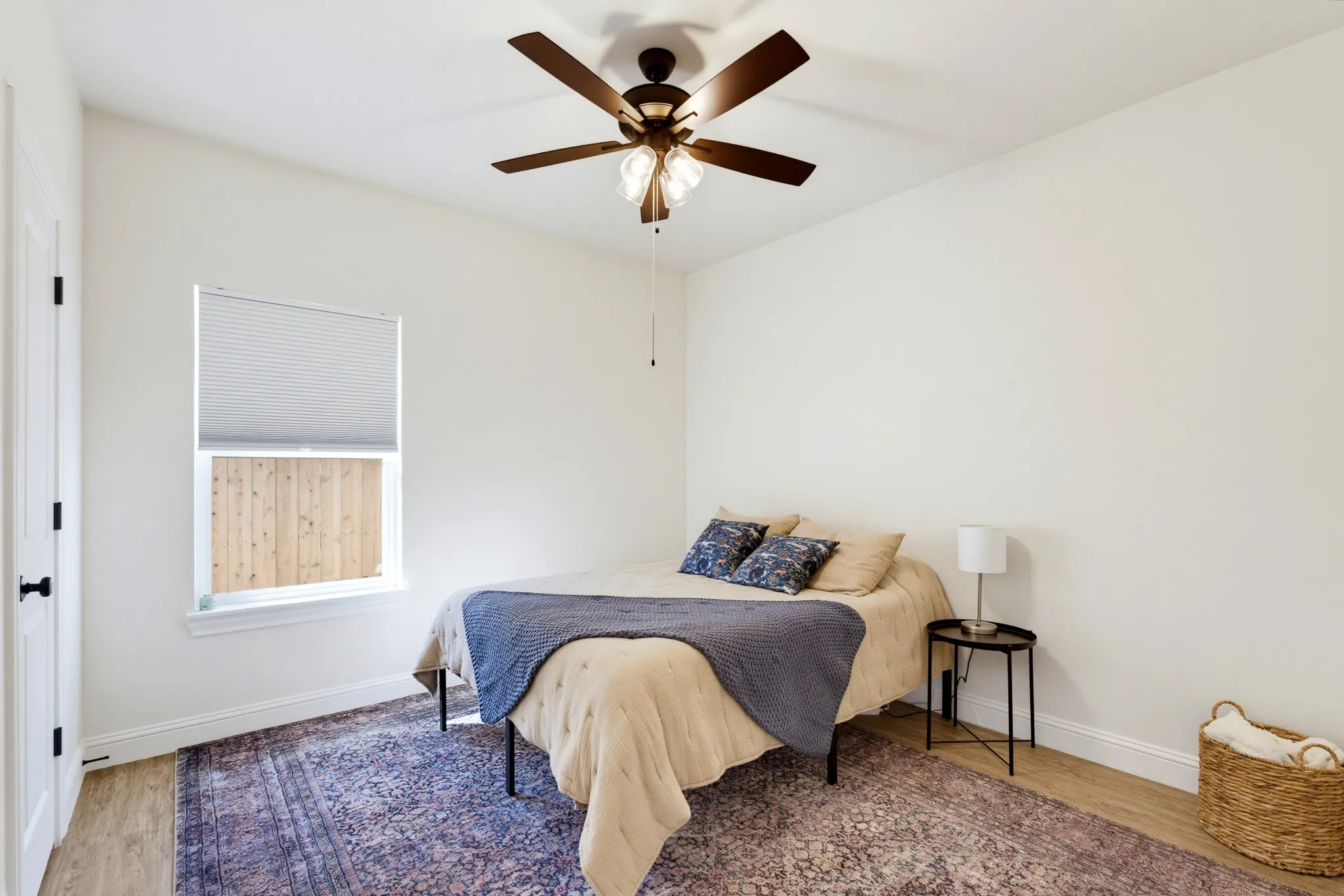 Recessed window with cellular blinds, wood-finish flooring, and ceiling fan