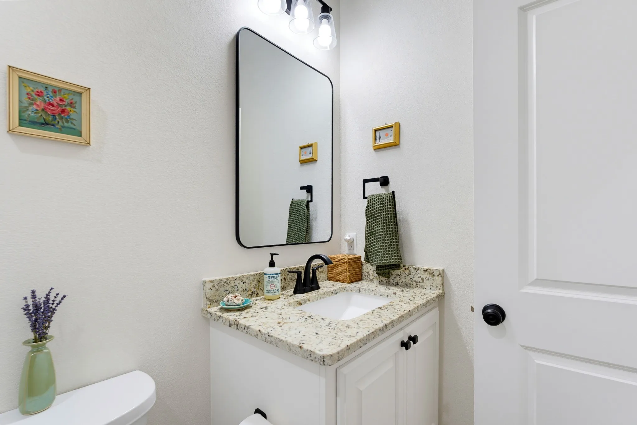 White vanity cabinetry with a light-toned countertop and an undermount sink