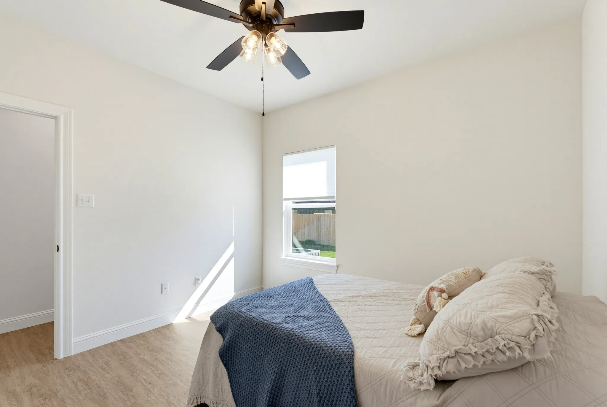 Wood-finish flooring, ceiling fan with integrated lighting, and a single window