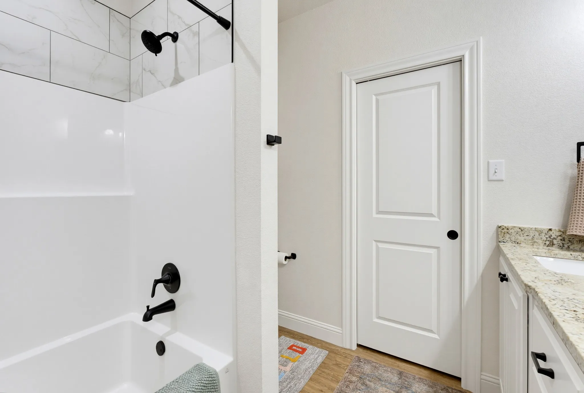 Tub/shower combination with matte black fixtures and subway tile surround