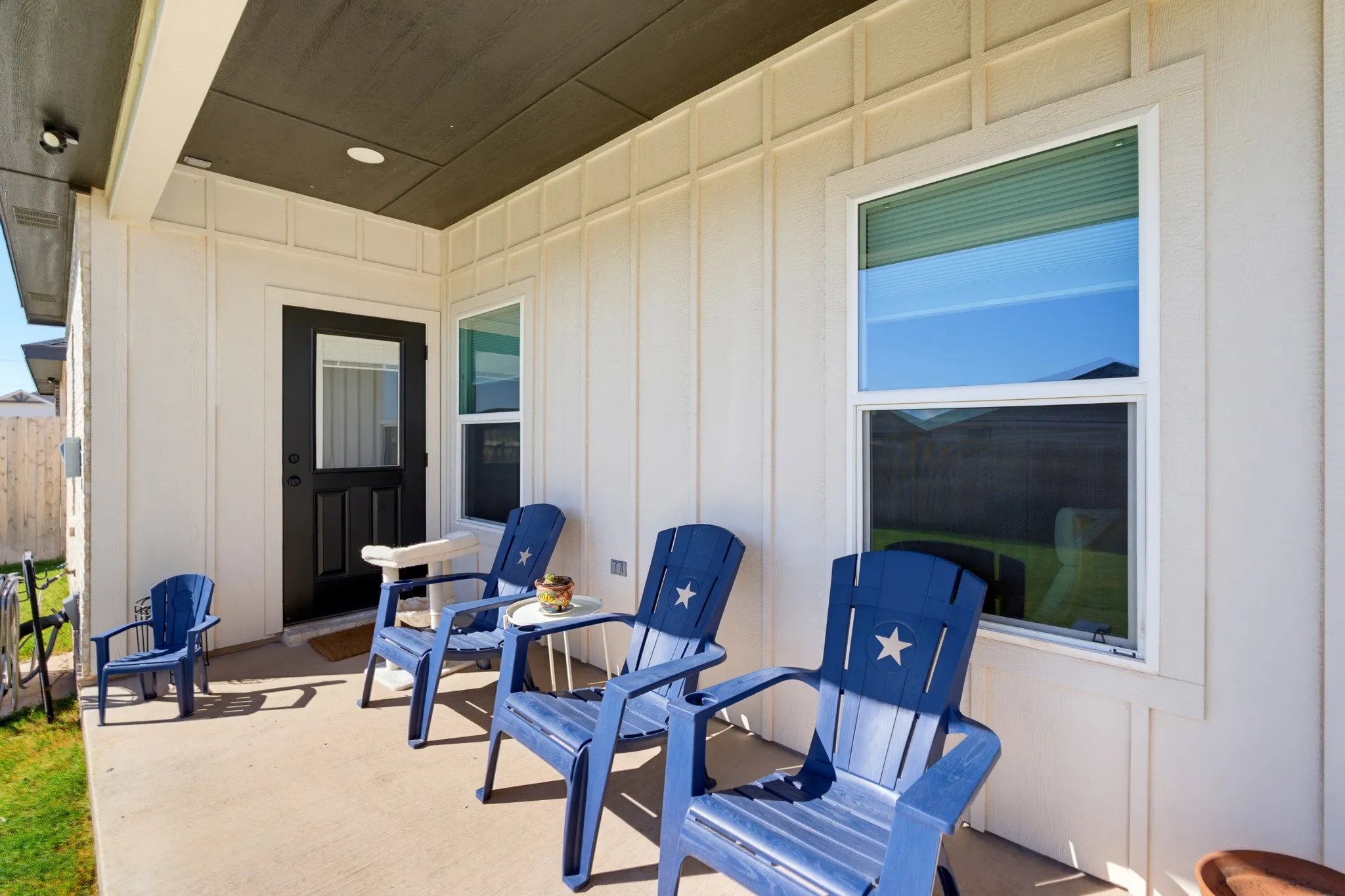Covered outdoor patio with a concrete surface, white board and batten siding, recessed lighting, and a dark-paneled ceiling
