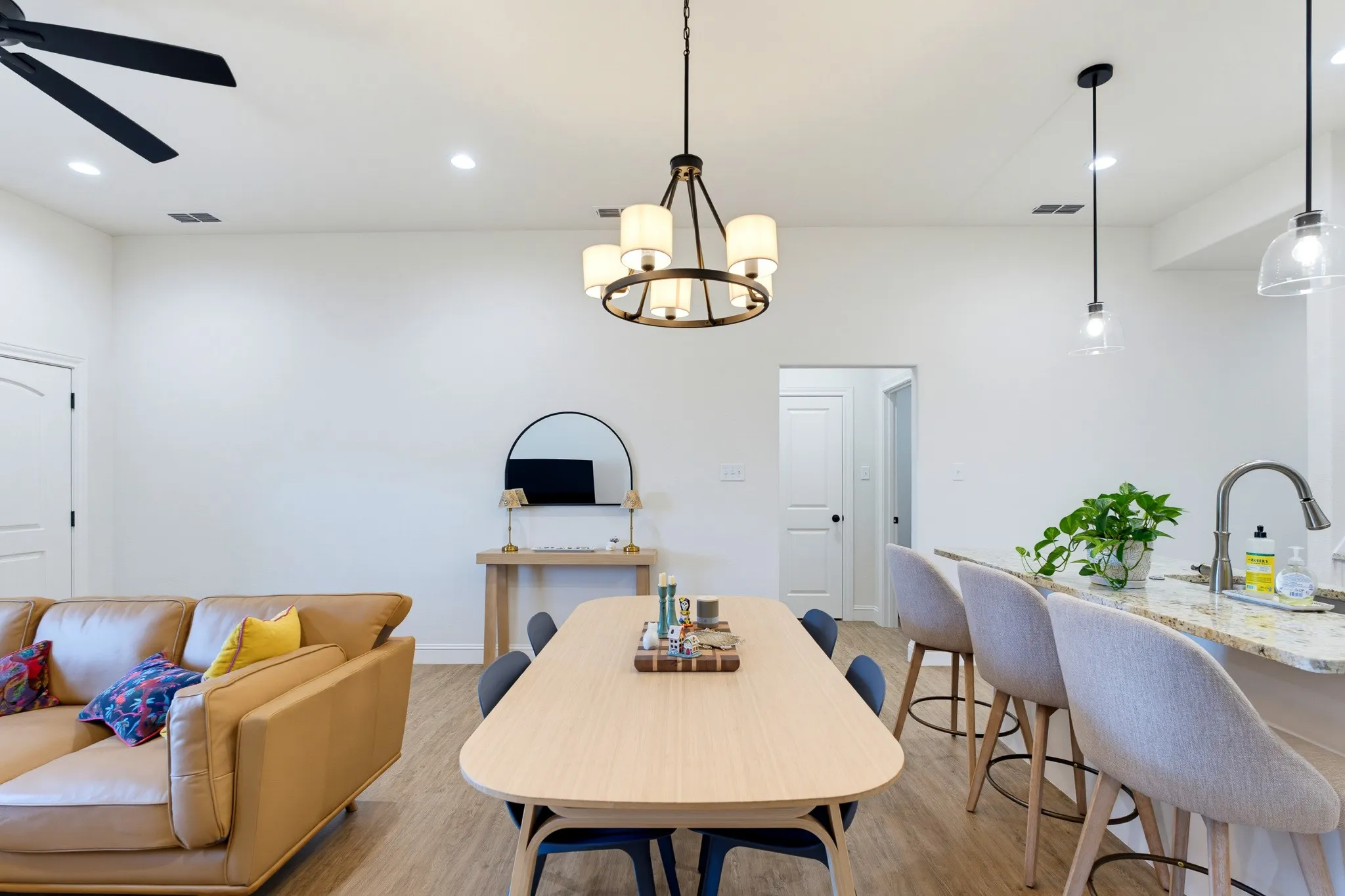 Open-concept living area with wood-finish flooring, recessed lighting, and a contemporary ceiling fan