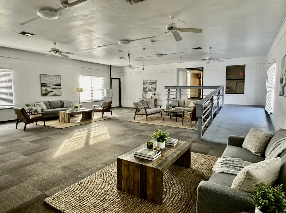 Spacious interior with high ceilings, multiple ceiling fans, and large windows