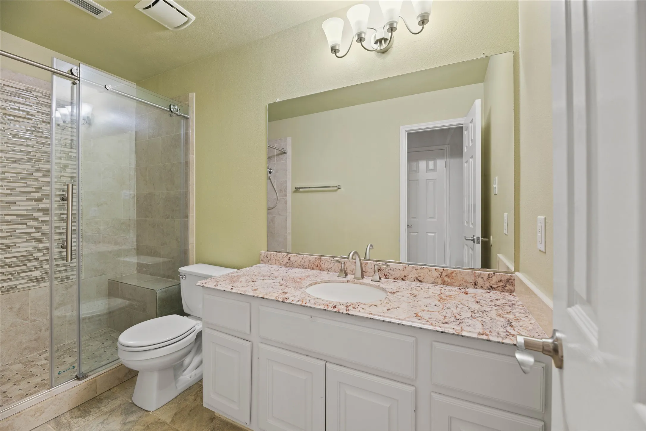 White vanity with a light-colored countertop, undermount sink, and brushed nickel faucet
