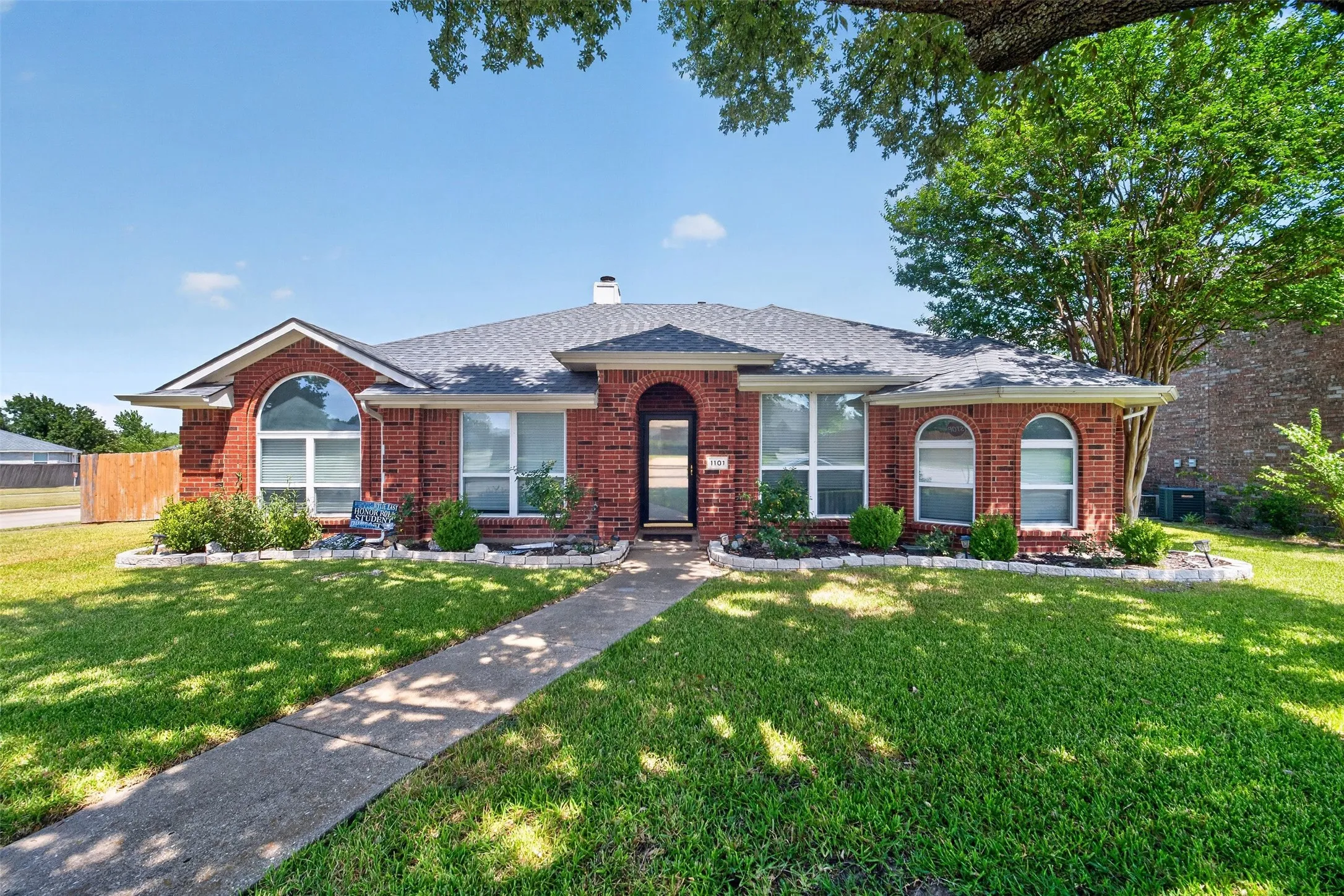 Red brick exterior with white trim, arched windows, and a dark shingle roof