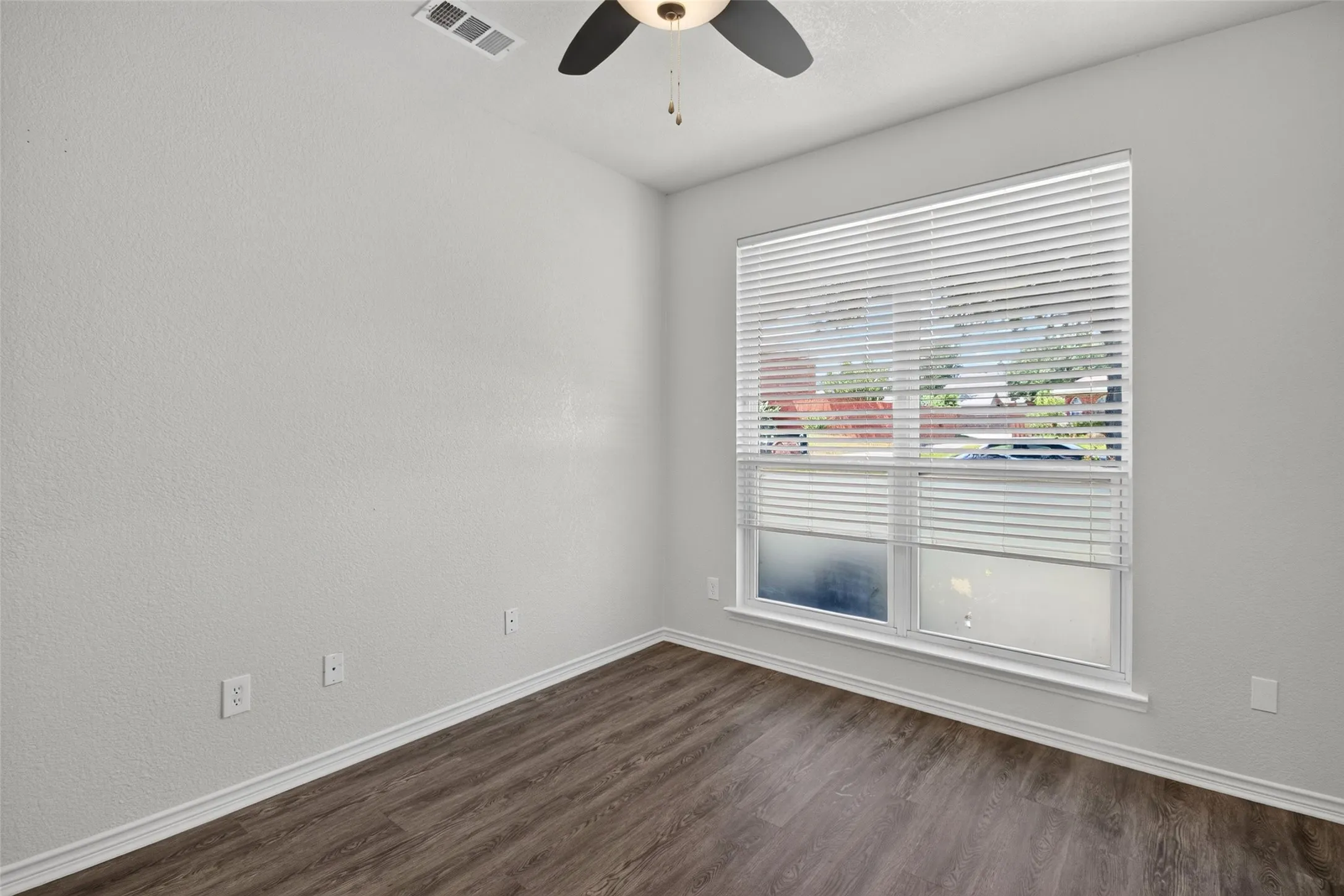 Recessed ceiling fixture, wood-finish flooring, and a large window with blinds