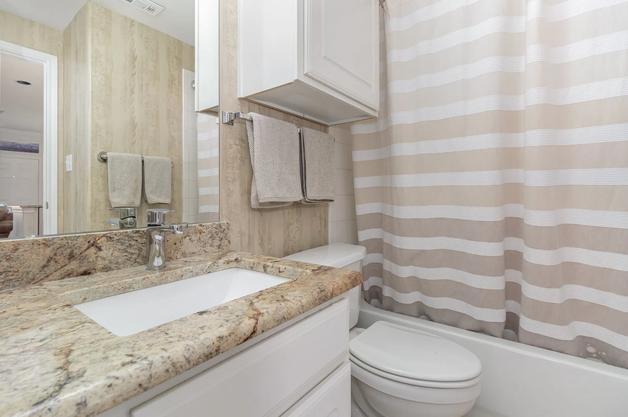 First floor full bath with granite counters, built-in cabinet, tub-shower combination.