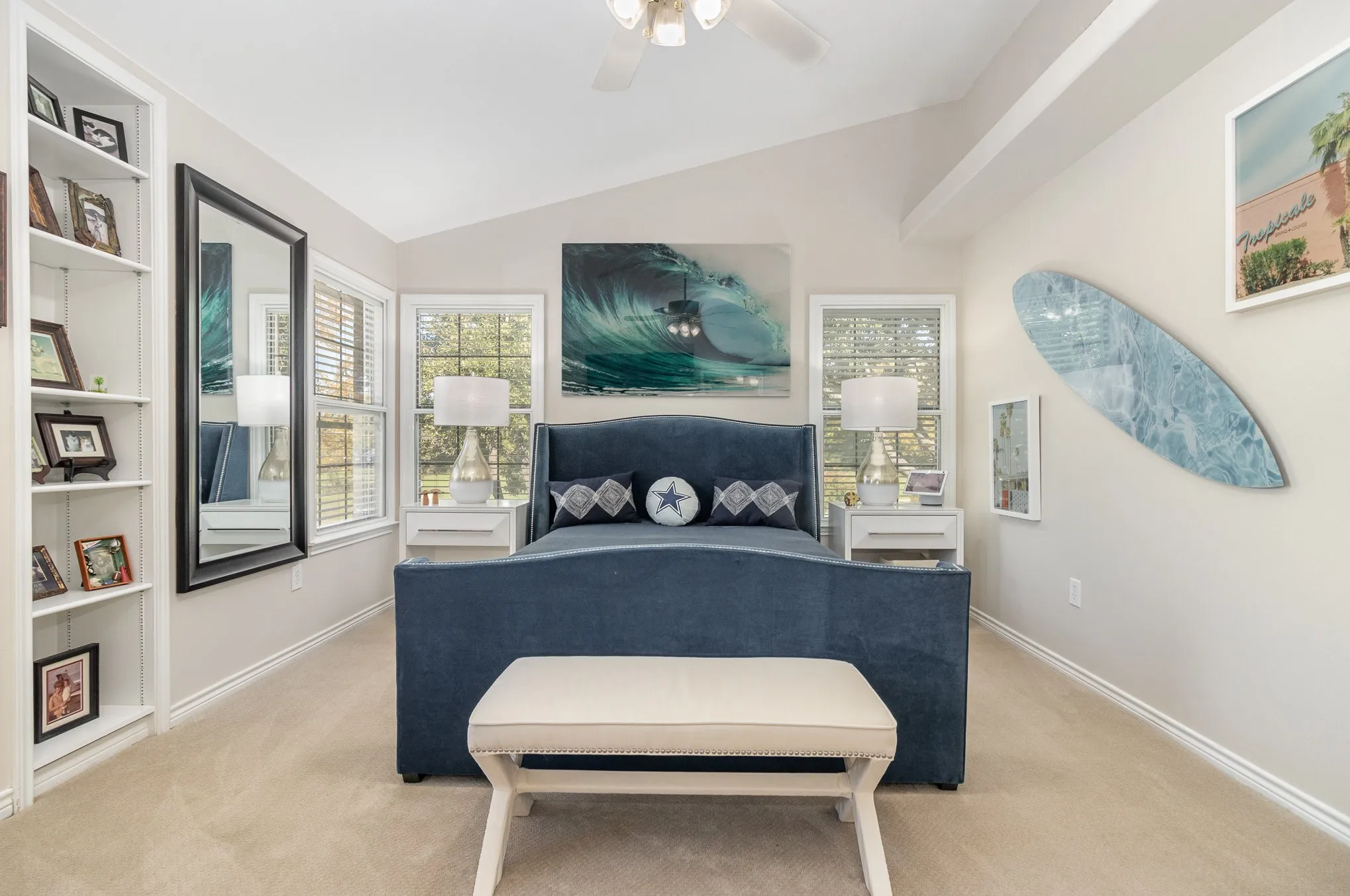 Primary bedroom with custom built-in shelving, vaulted ceiling, added upper shelf, lighted ceiling fan.
