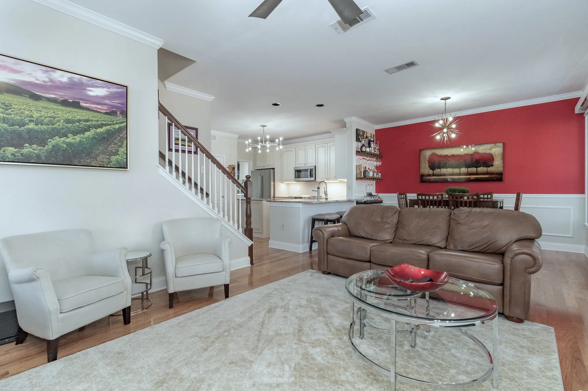 Living area is adjacent to dining and kitchen. Wood flooring throughout the open living areas.
