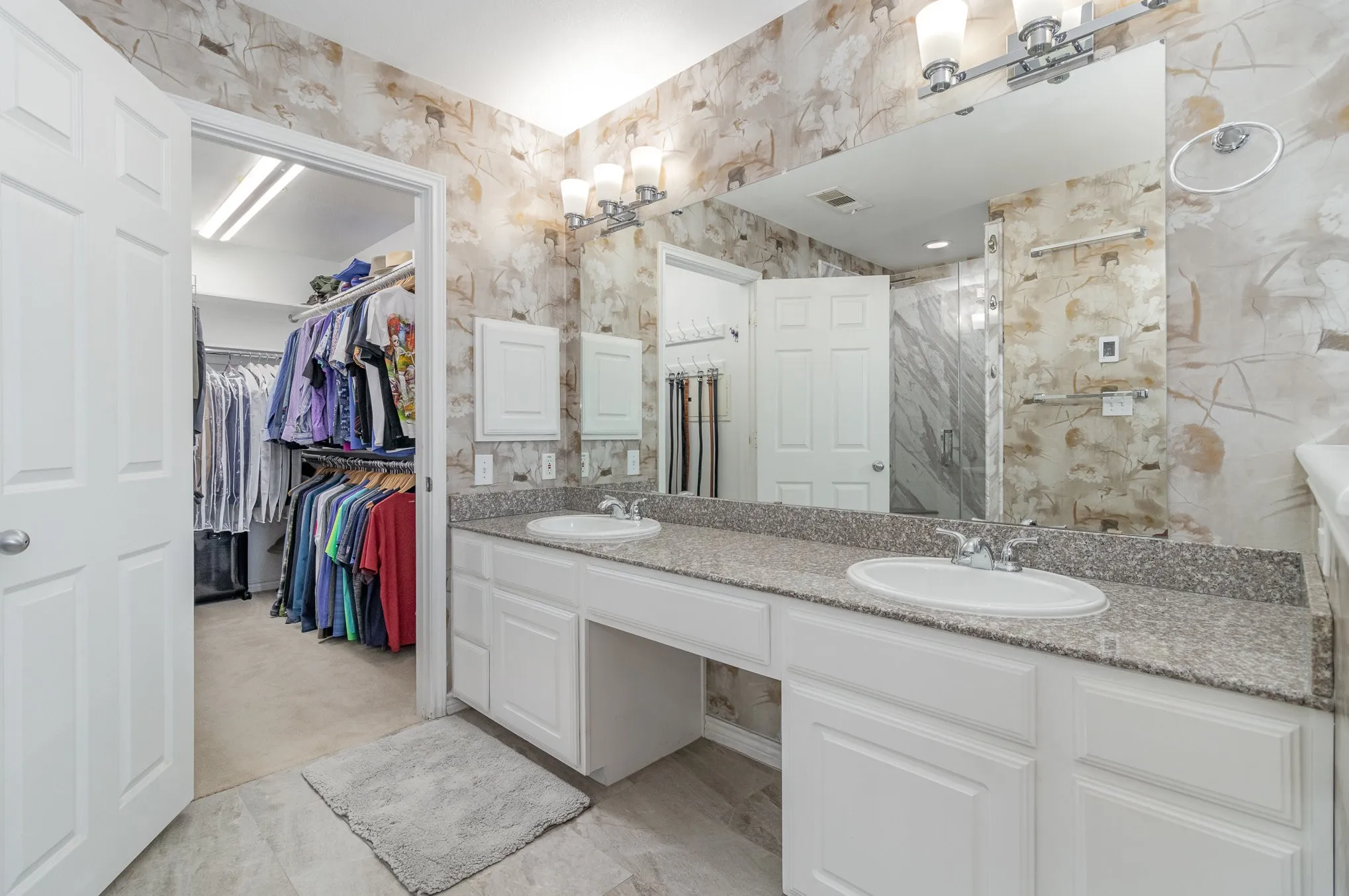 Primary bath has dual sinks, new light fixtures, designer wallpaper, new floor tile and HEATED floors!  Walk-in closet was custom-designed.