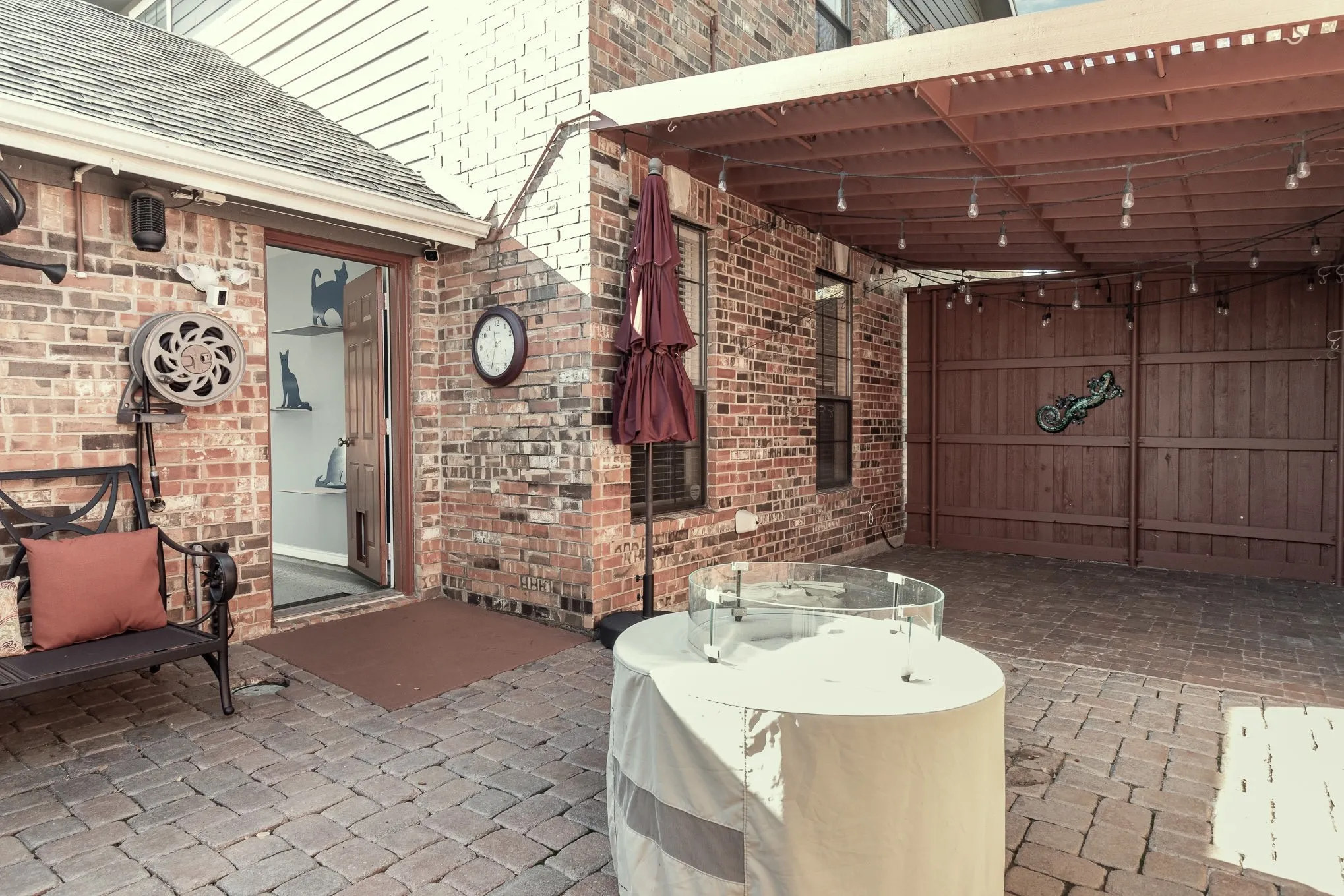 Side yard has brick paving (low maintenance), is partially covered, has fire pit, water feature and awning.