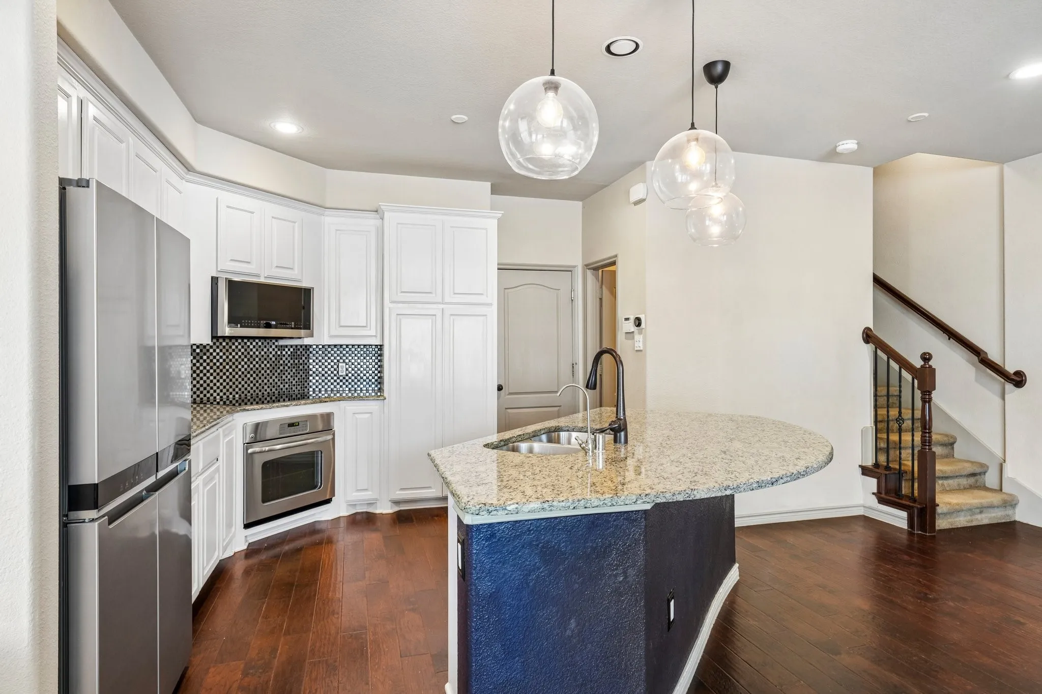 Gourmet kitchen featuring stainless steel appliances, white cabinetry, and granite countertops
