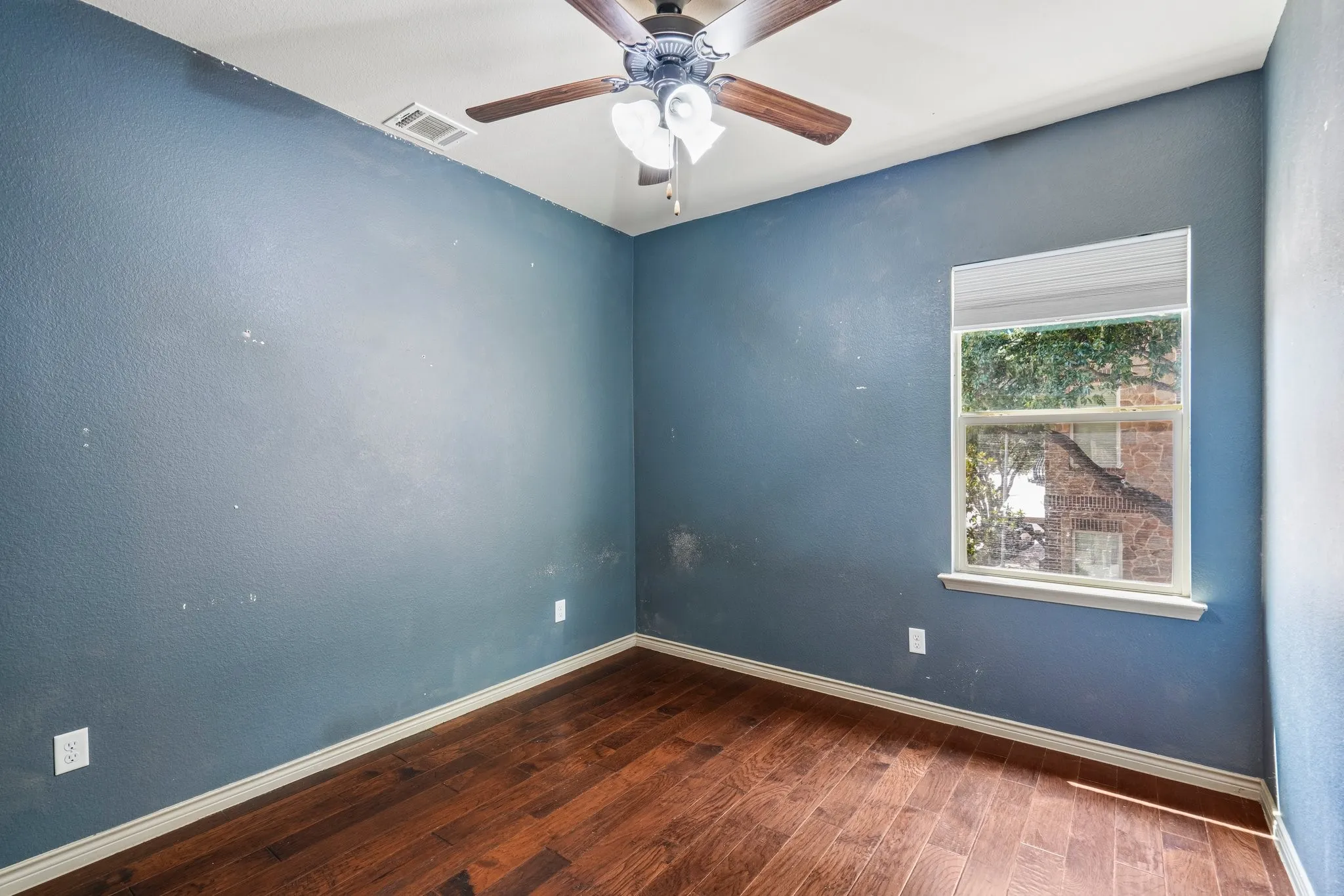 Wood-finish flooring, single window, ceiling fan with light fixture