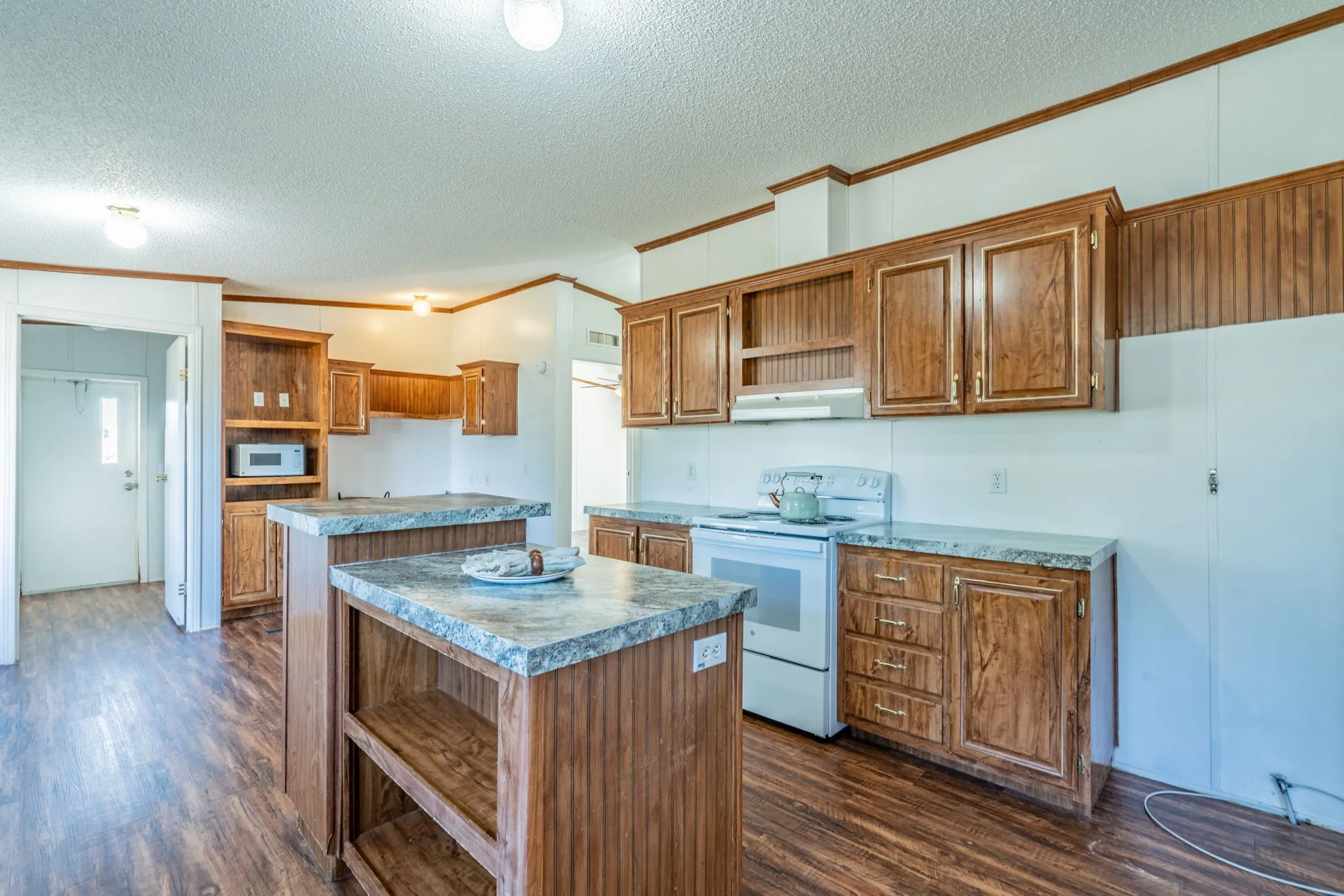 Kitchen: Additional view showcasing the electric range, open-shelf island, and convenient countertop work areas.