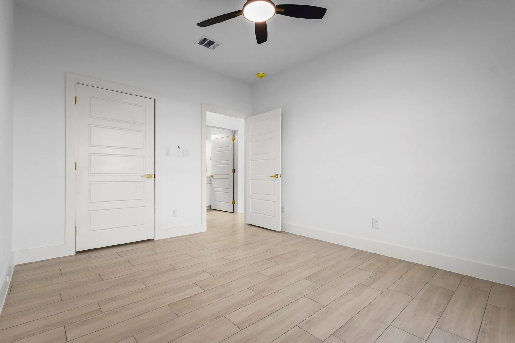 Recessed lighting, wood-finish flooring, white paneled doors, ceiling fan with light fixture, and neutral wall tones