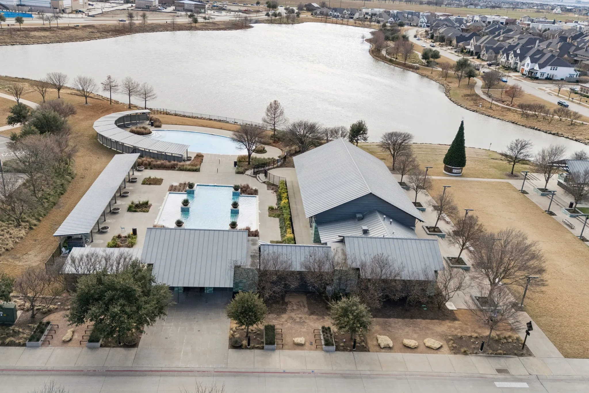 Community recreation center featuring multiple pools, expansive green spaces, and direct water frontage