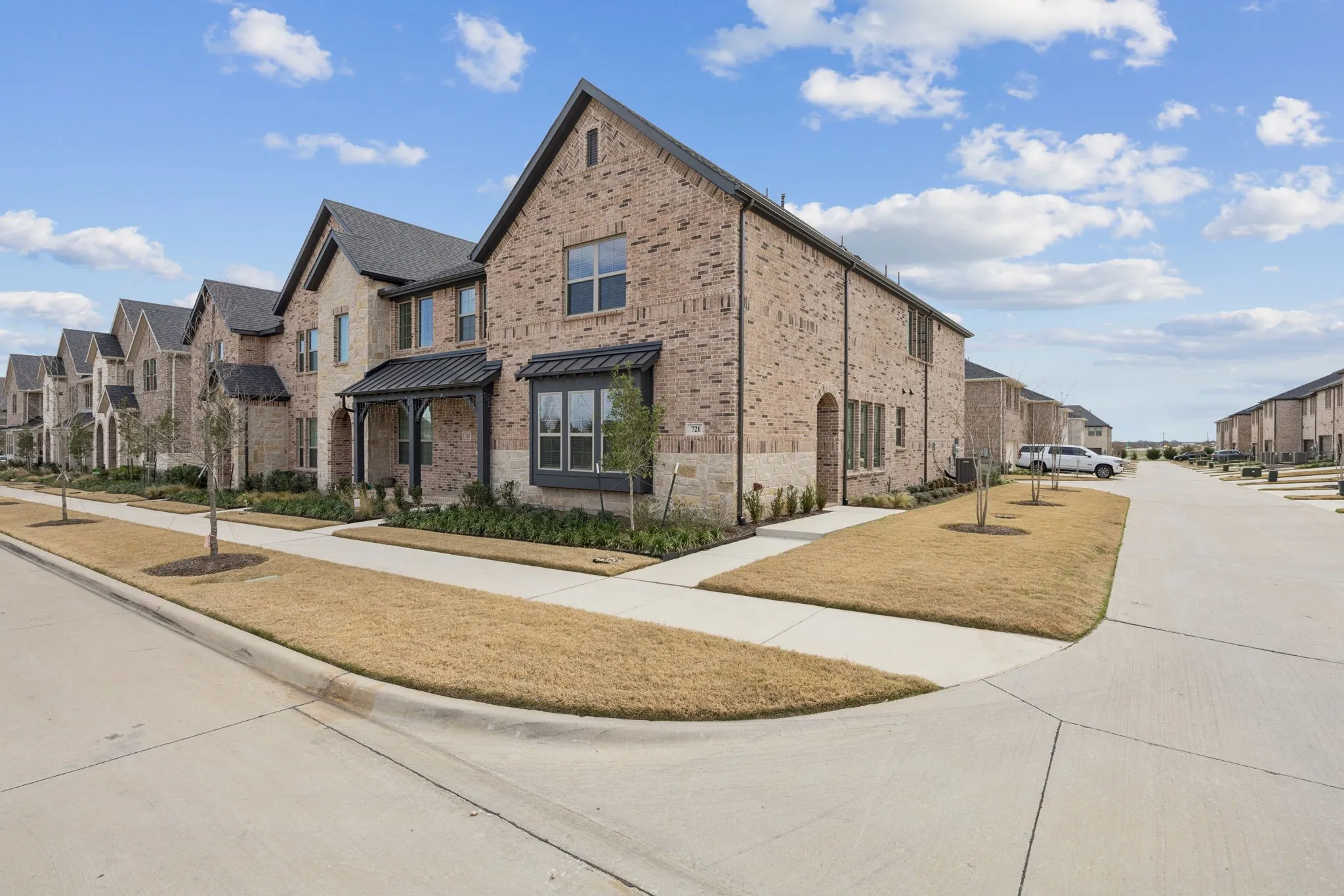 Brick exterior with stone accents, covered entry, and black-framed windows