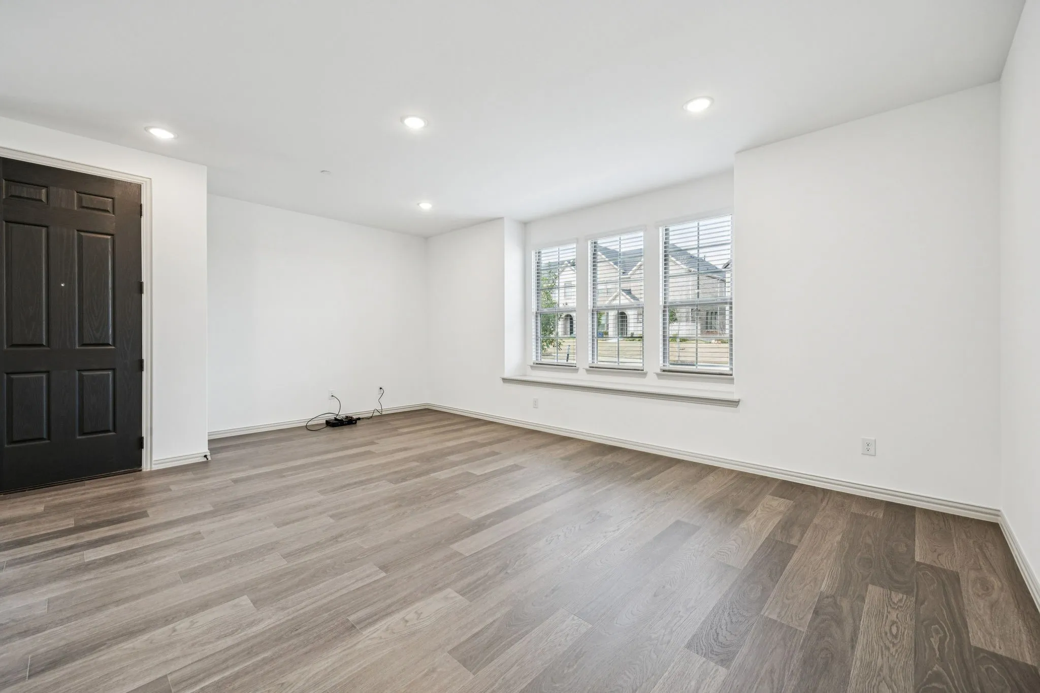Neutral color palette, recessed lighting, wood-finish flooring, white trim, and multiple windows