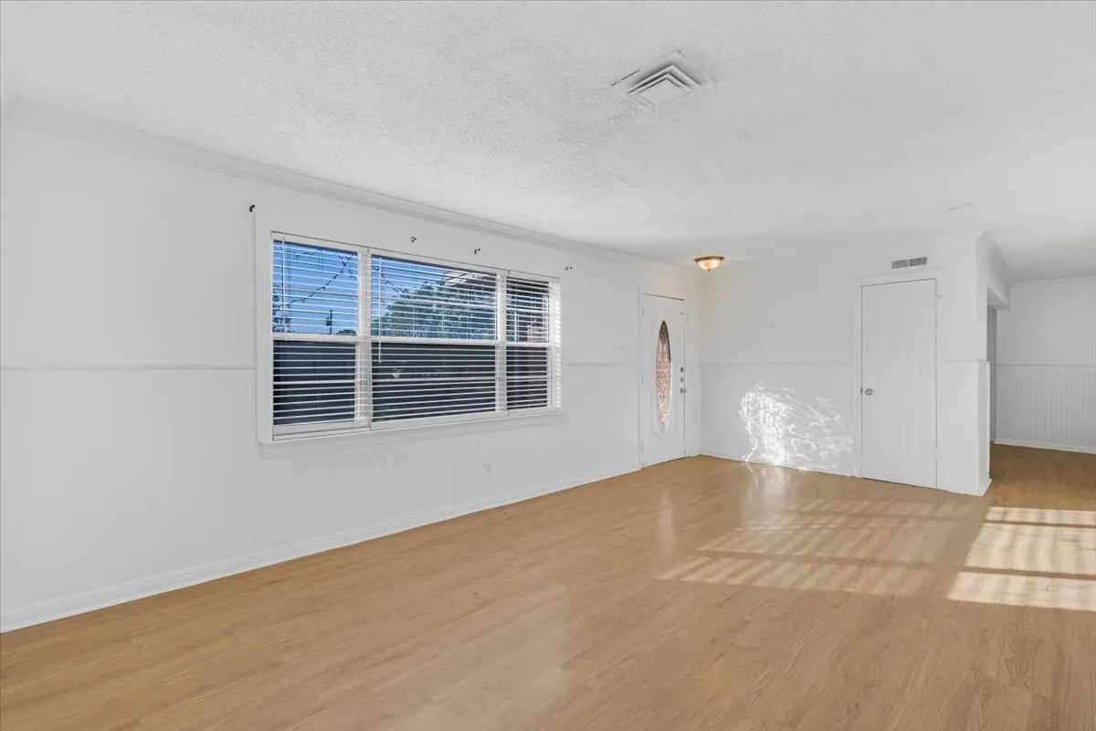 Hardwood-finish flooring, white paneled walls, and built-in overhead lighting