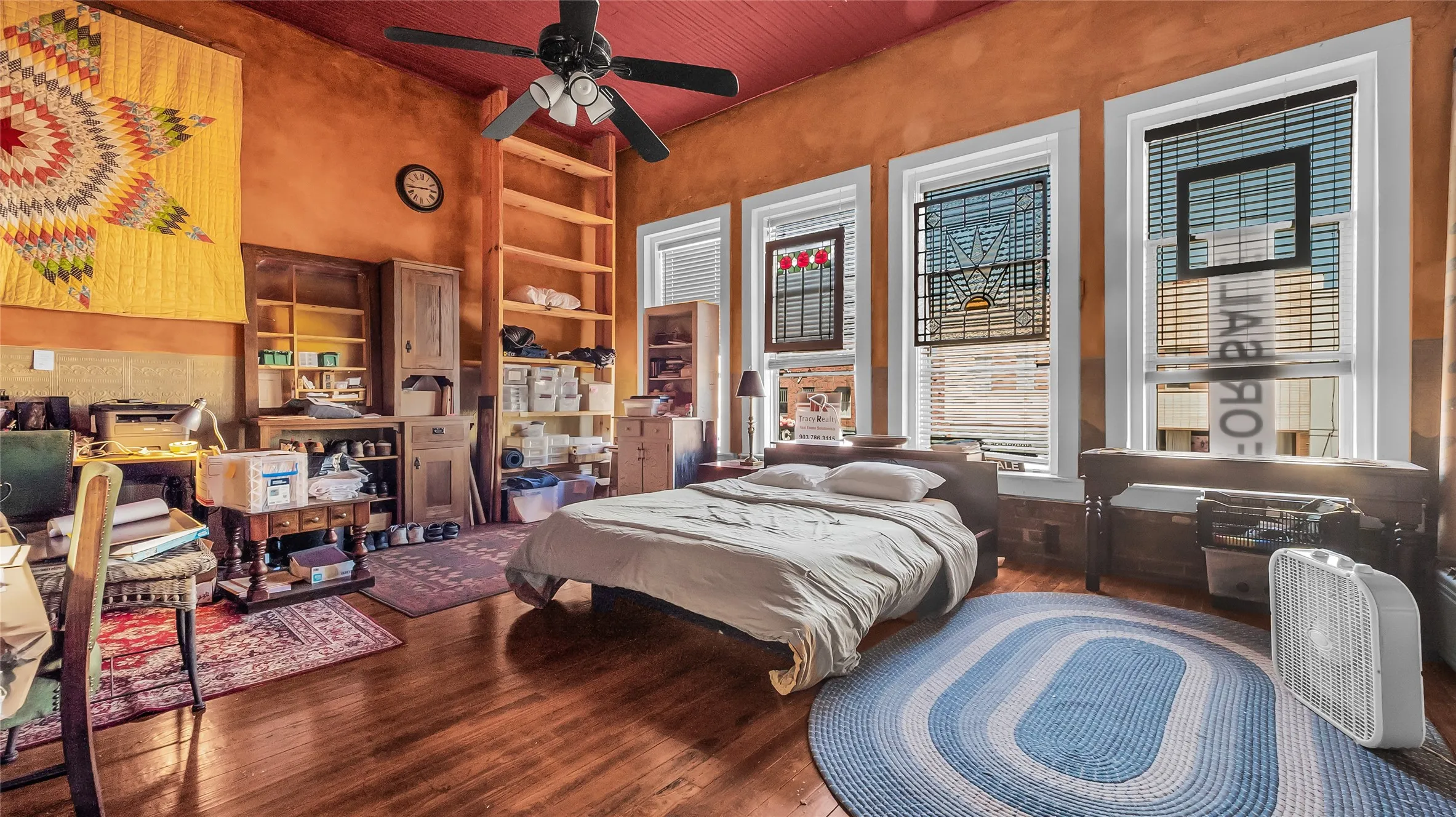 Hardwood flooring, painted ceiling, ceiling fan, and multiple windows with blinds