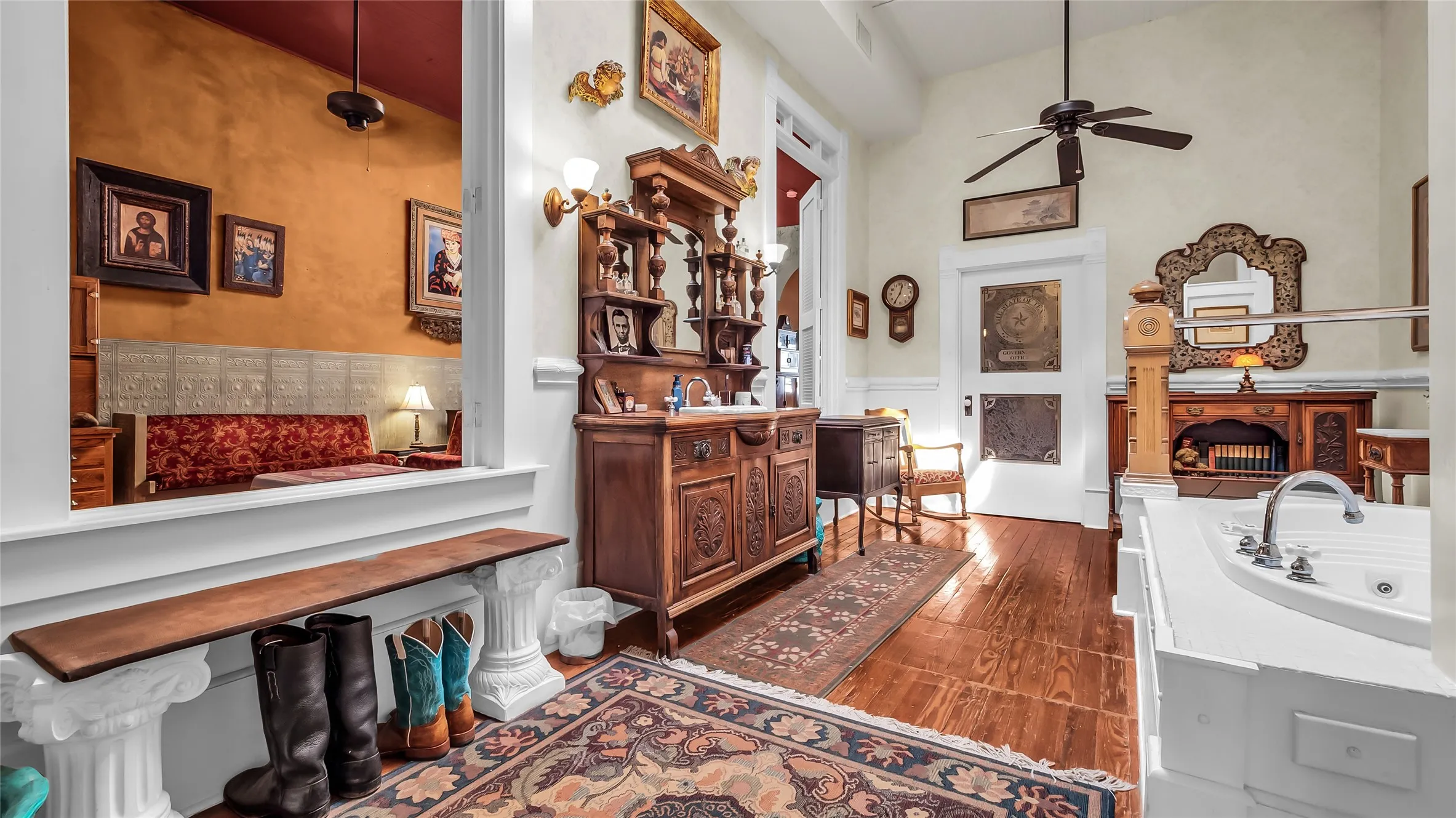 Vaulted ceiling with a ceiling fan, wood-finish flooring, and a built-in jetted tub