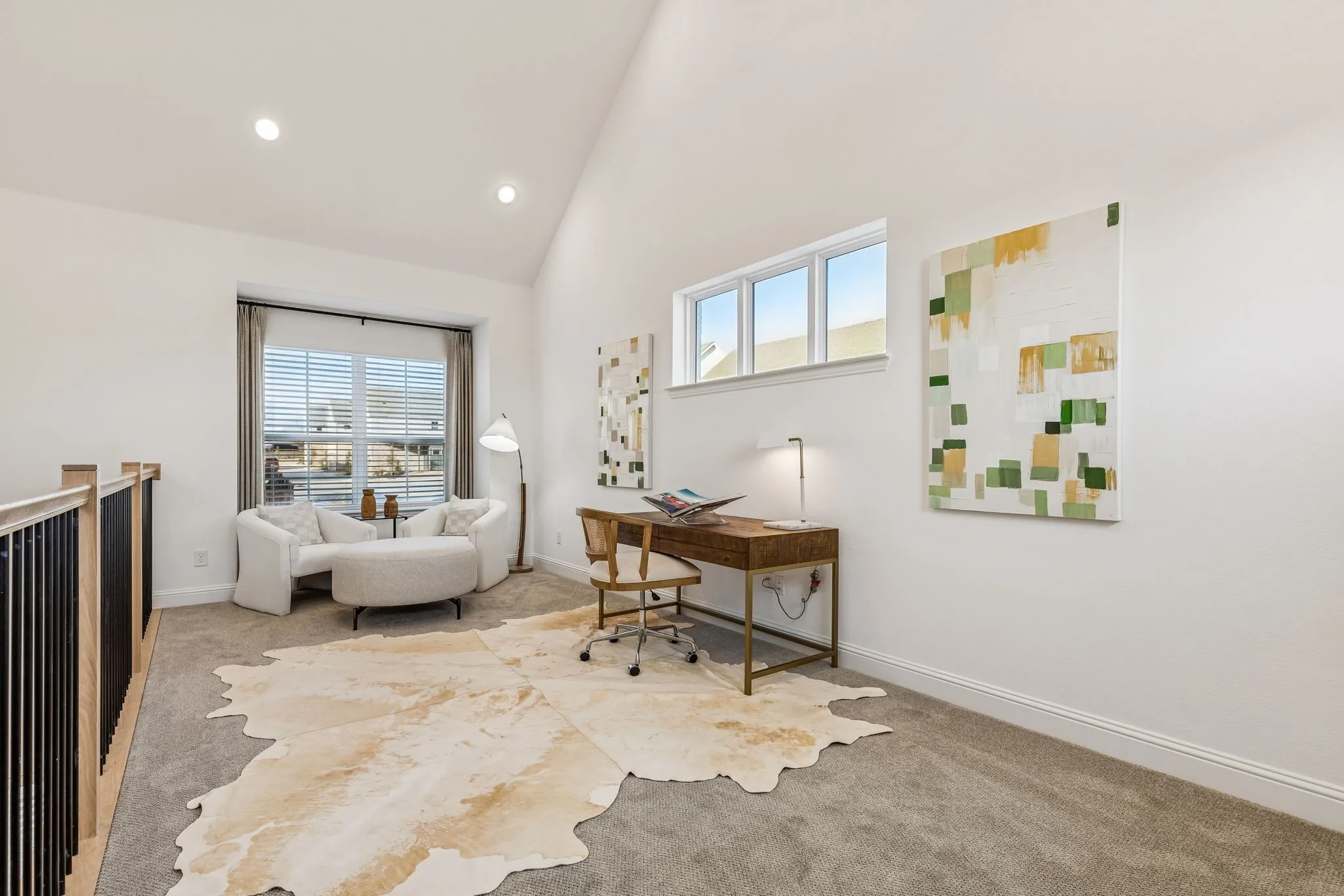 Vaulted ceiling with recessed lighting, large window with blinds, additional high window, carpeted flooring, and a wood-finish railing with black balusters