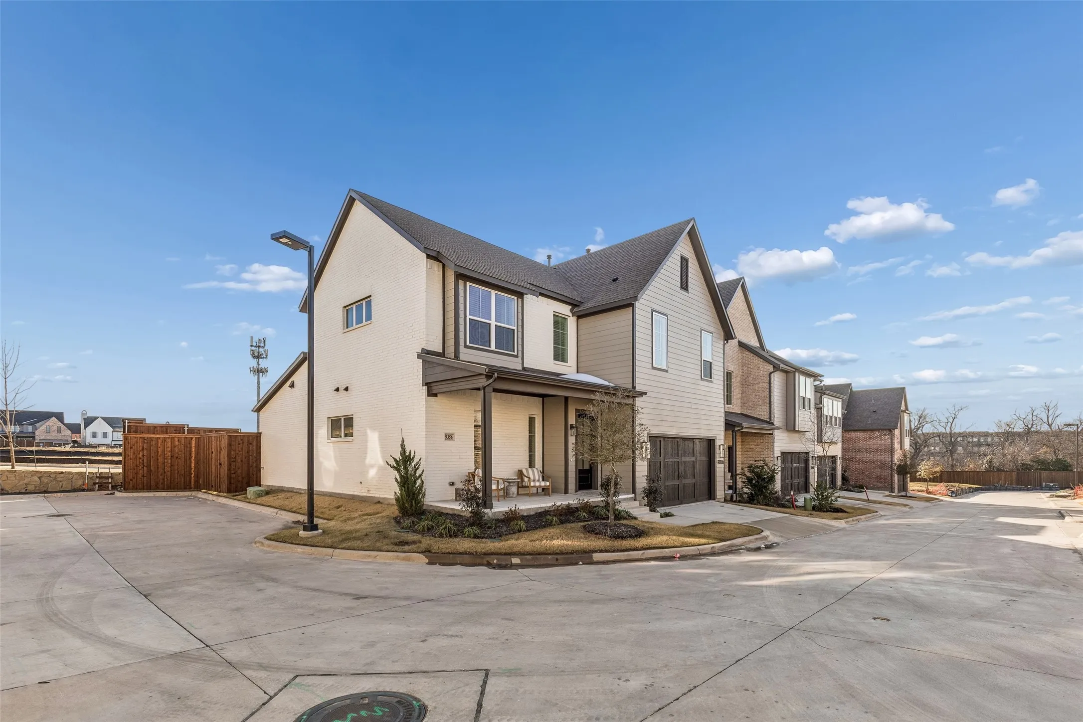 Modern townhome featuring a two-story design, a covered entry porch, an integrated single-car garage, and a gabled roofline