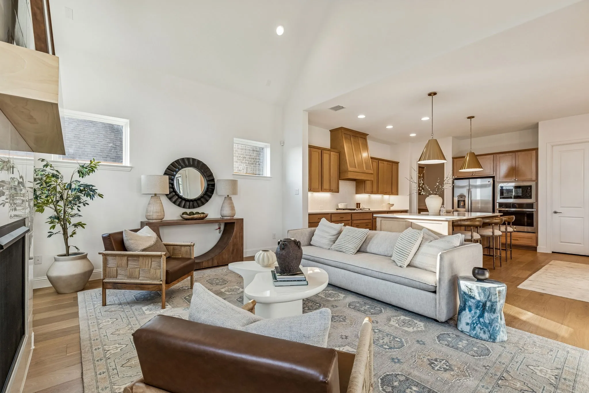 Vaulted ceiling, wood-finish flooring, recessed lighting, kitchen island with seating, pendant lighting