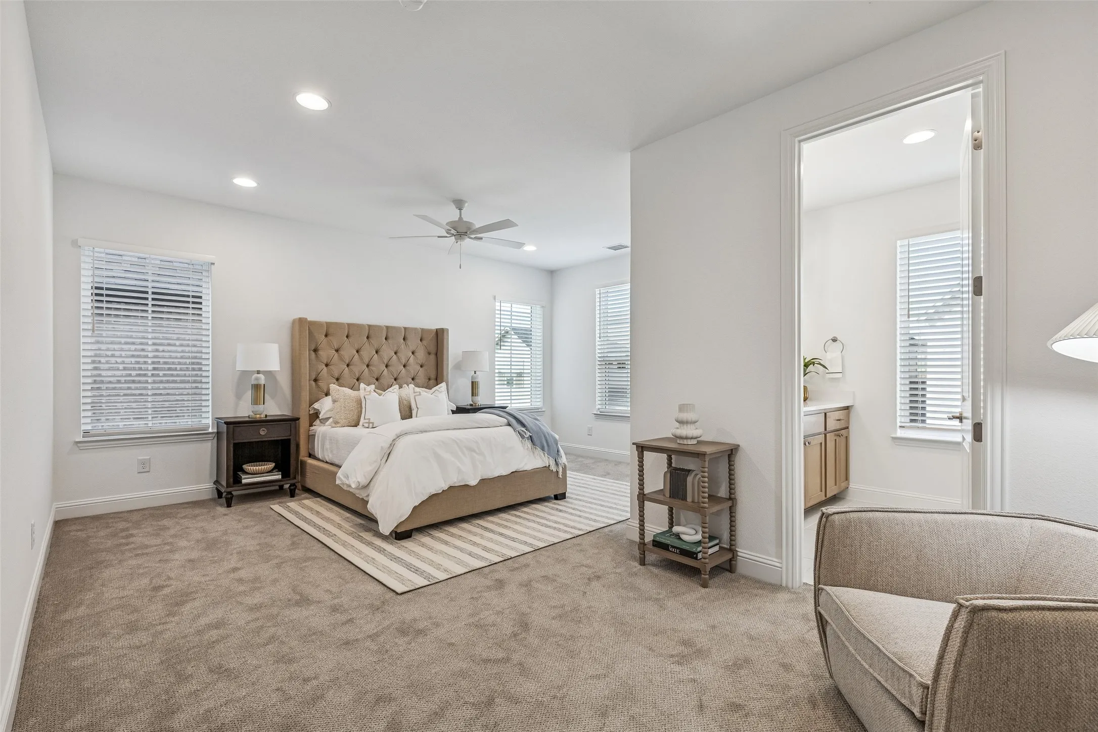 Carpeted flooring, recessed lighting, ceiling fan, multiple windows with blinds, and white interior doors