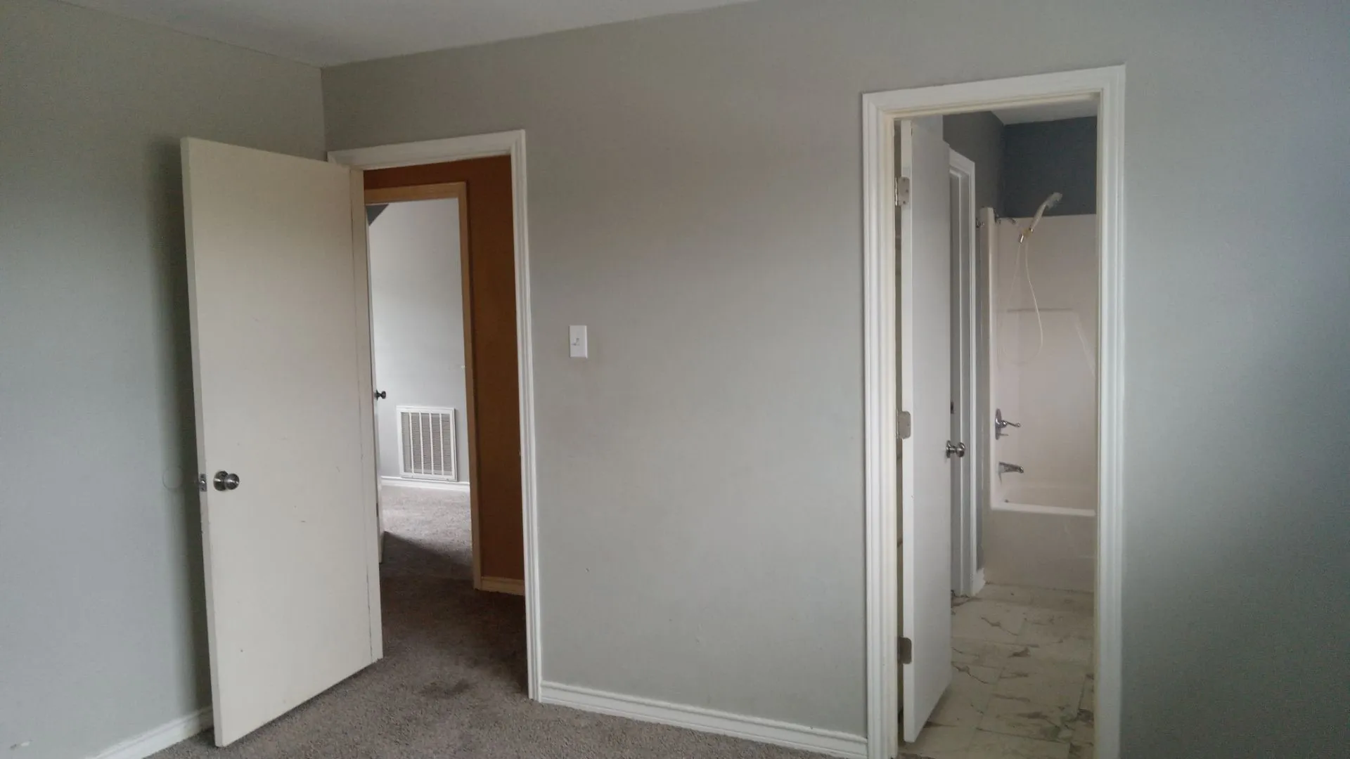 Neutral wall finishes, carpeted flooring, and a full bathroom with a shower-over-tub combination