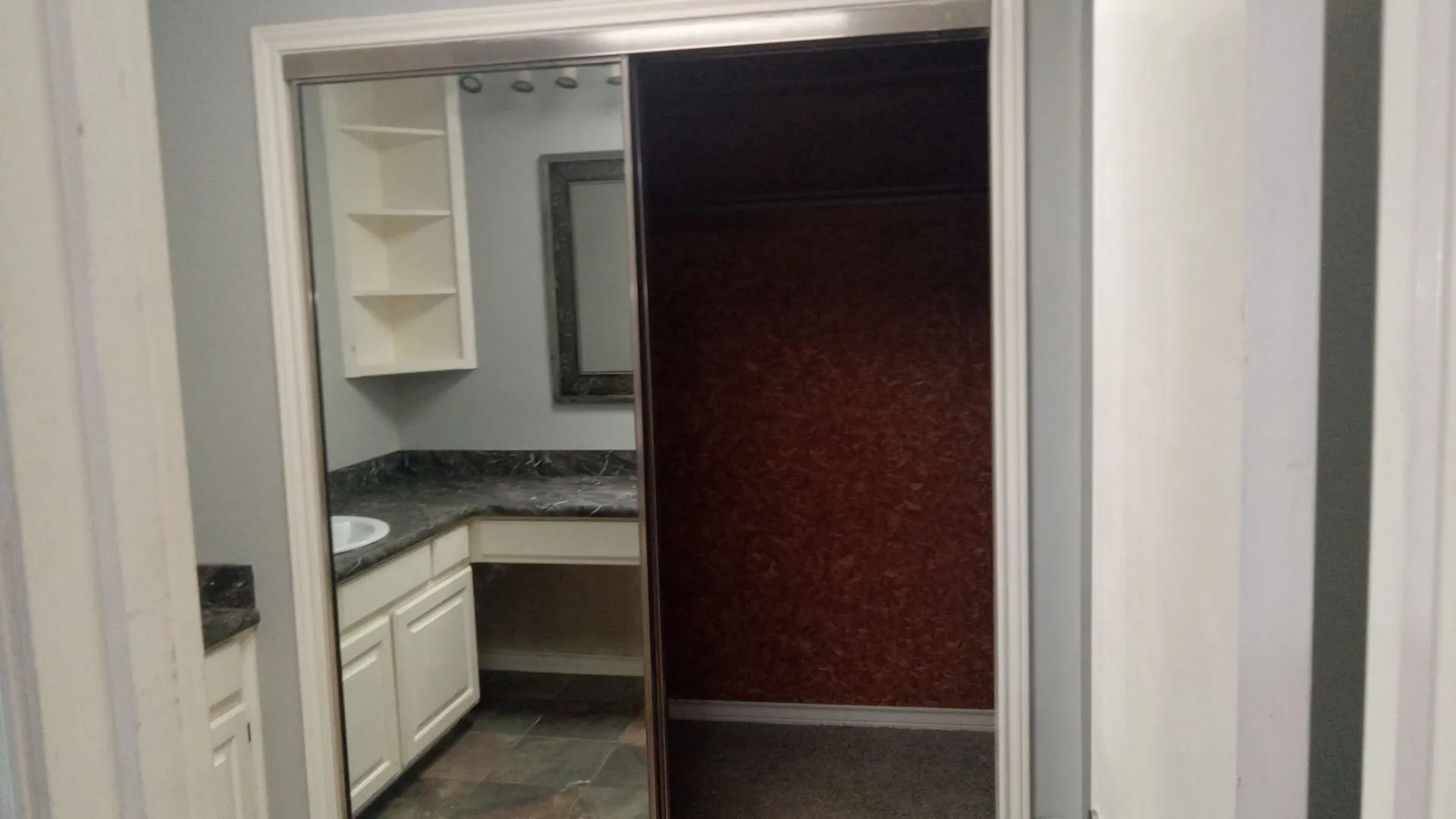 Mirrored sliding closet door with a white frame
