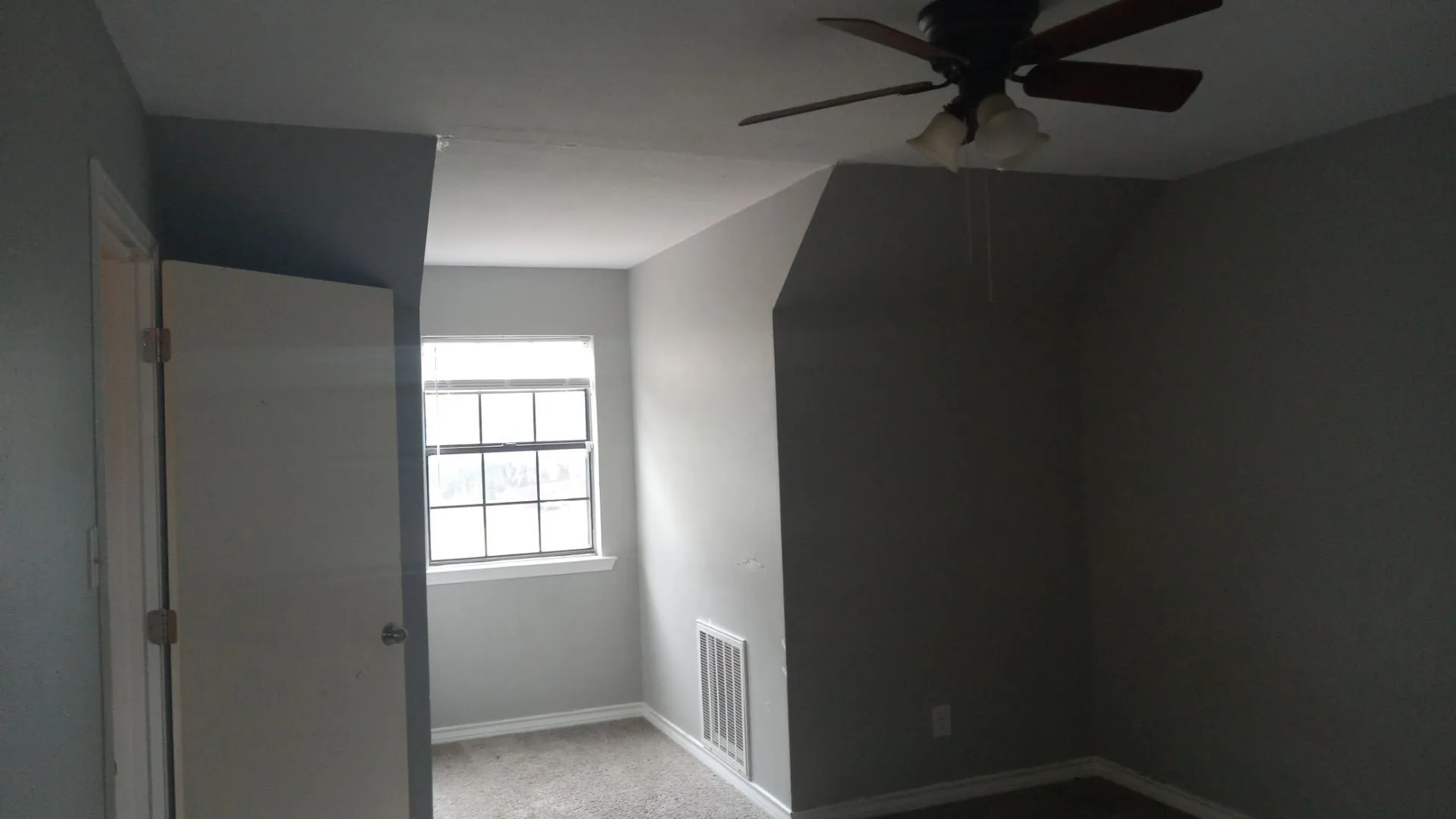 Sloped ceiling bedroom featuring a ceiling fan with integrated lighting, a double-hung window, and neutral wall tones