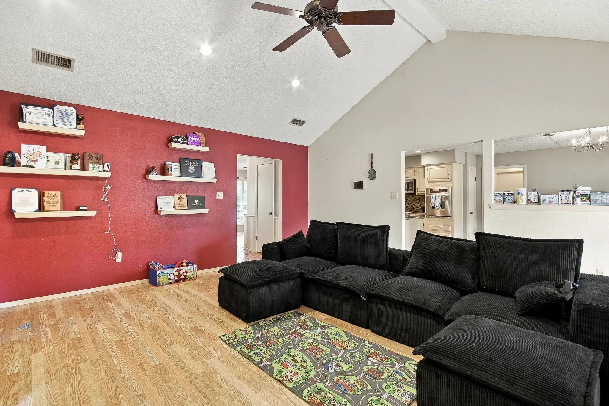 Vaulted ceiling with a ceiling fan, recessed lighting, wood-finish flooring, and built-in shelving