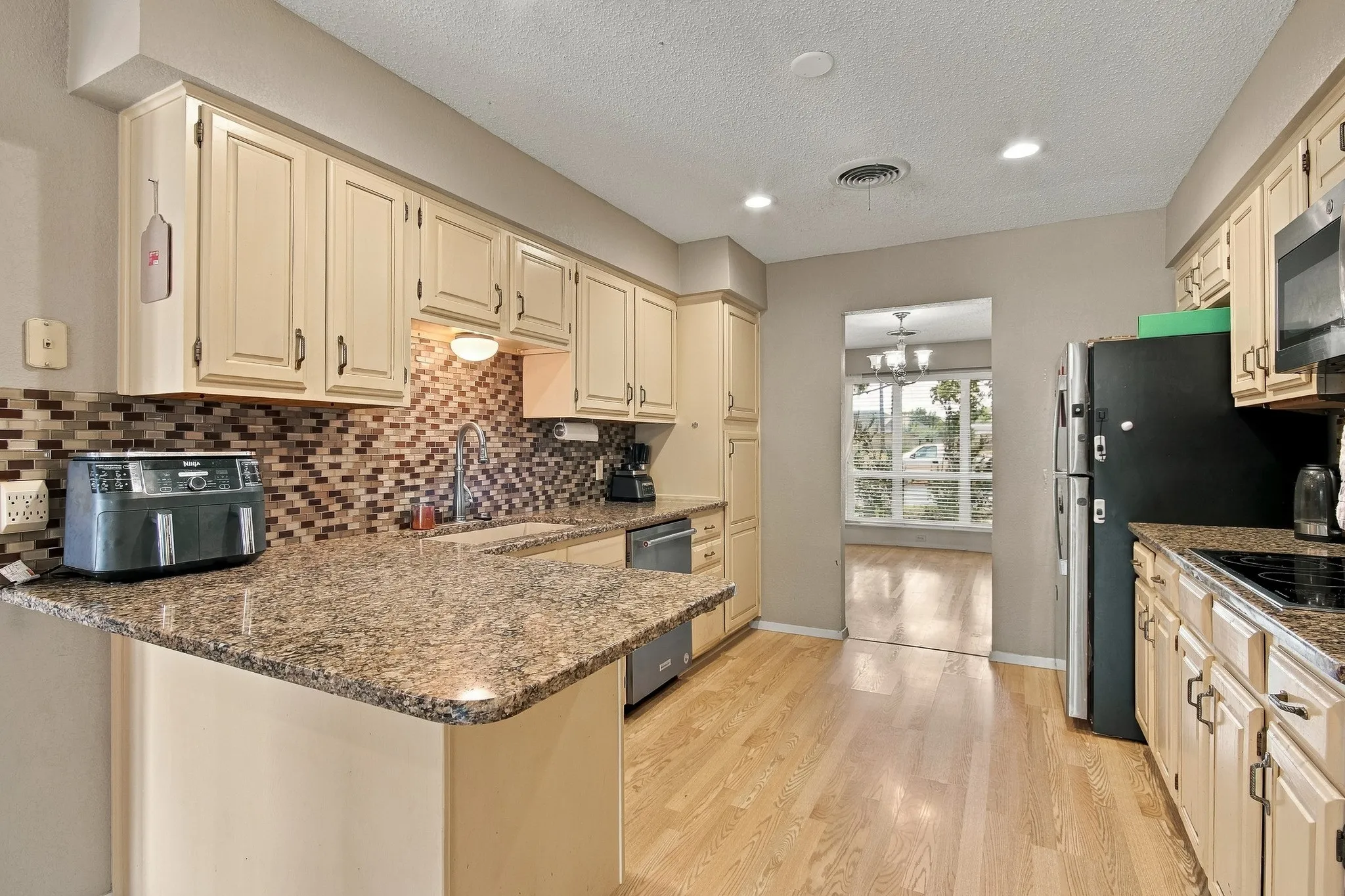 Kitchen featuring wood-finish flooring, recessed lighting, and a tile backsplash