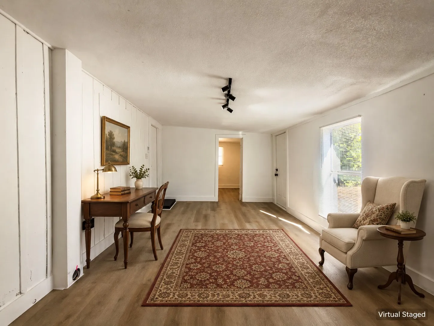 Wood-finish flooring, white paneled wall, recessed window, track lighting, and white trim