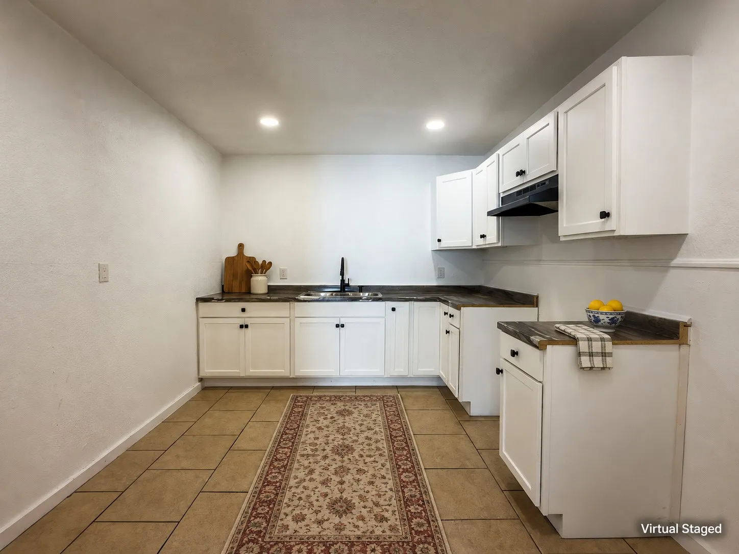 White cabinetry with matte black hardware, dark wood-finish countertops, and a black sink faucet