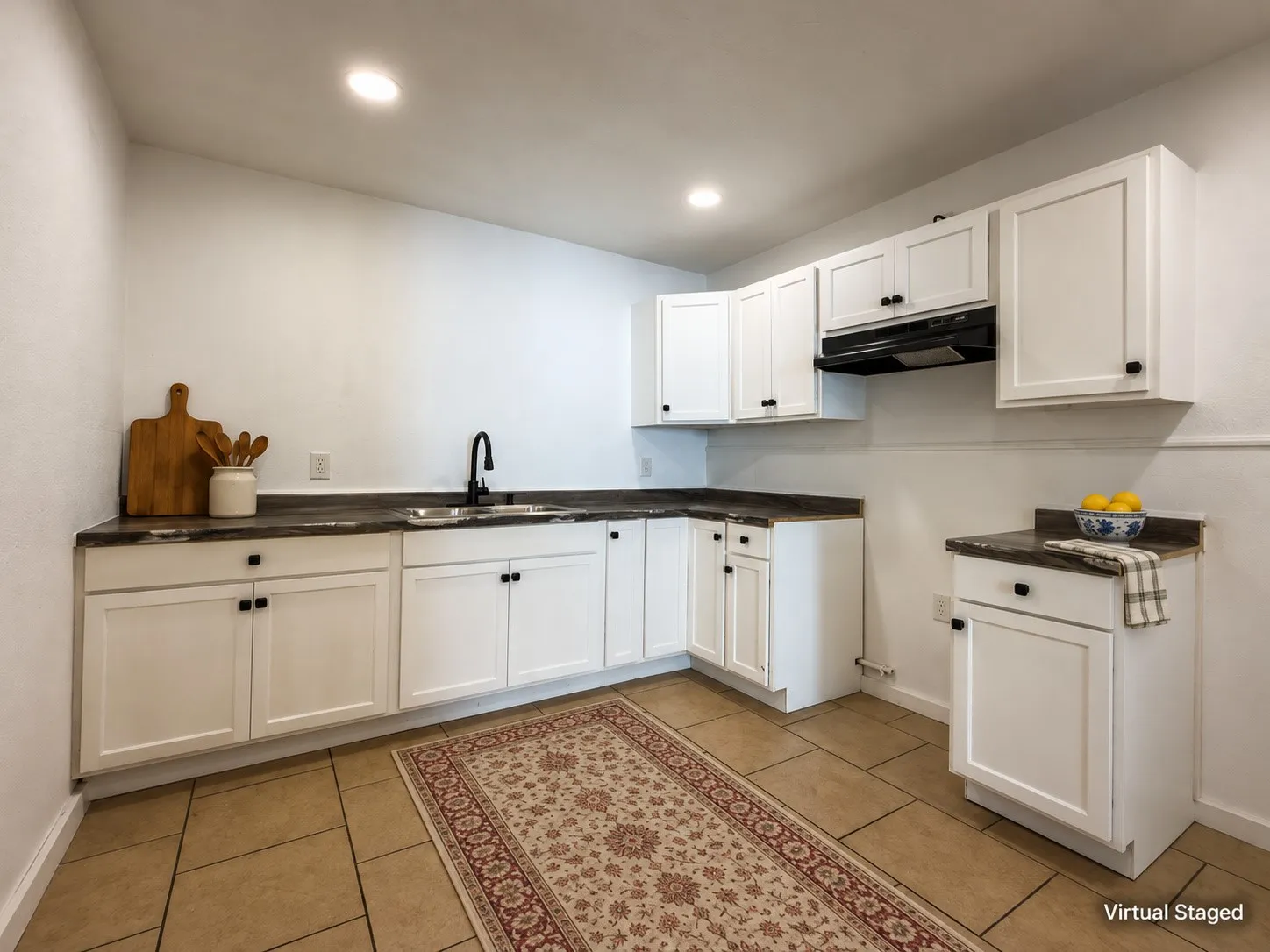 White shaker cabinetry with dark hardware, dark countertops, a black gooseneck faucet, an undermount sink, and tiled flooring